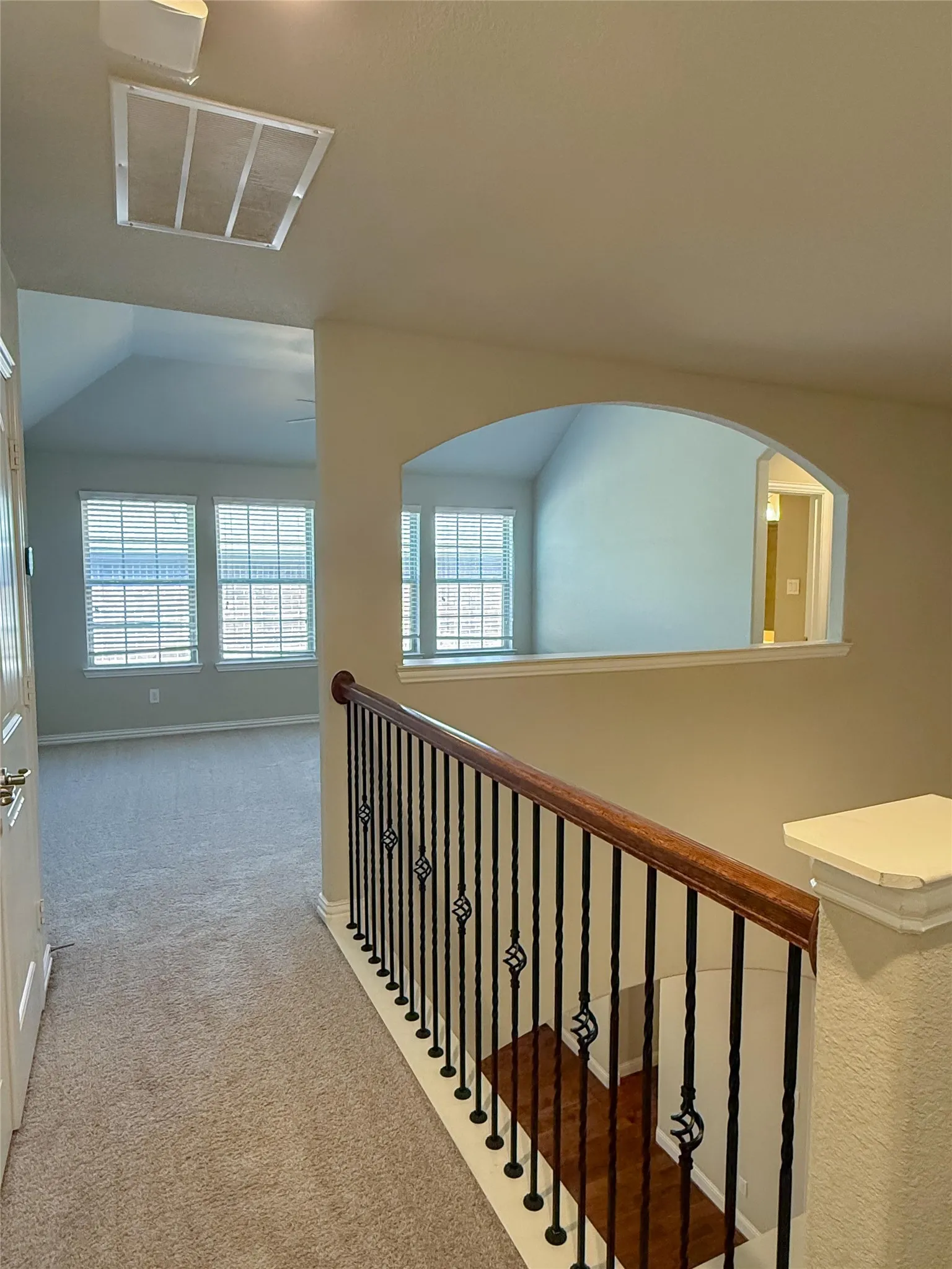 Staircase with wrought iron balusters and a wood handrail