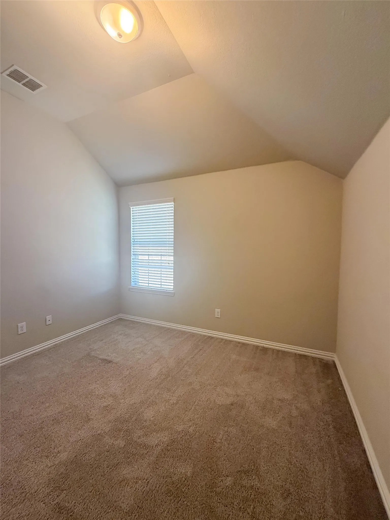 Sloped ceiling, recessed lighting, carpet flooring, window with blinds, and neutral wall tones