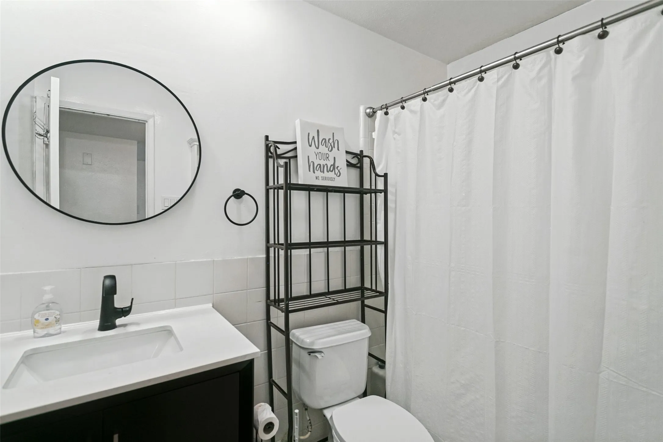 Vanity with integrated sink, black cabinet, and matte black faucet