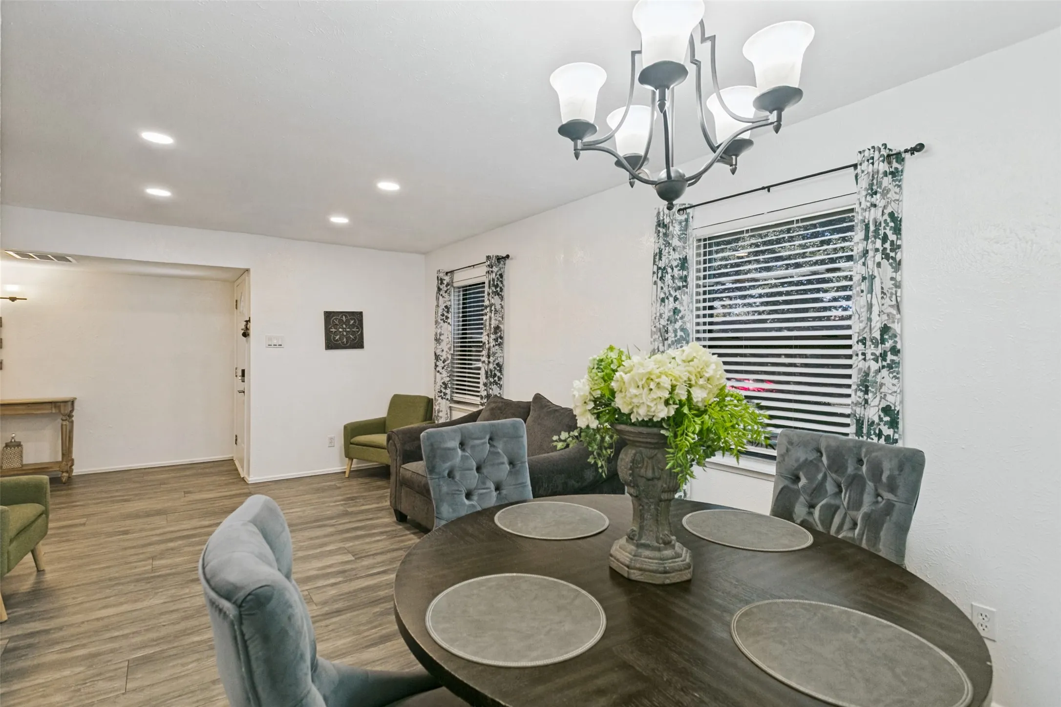 Recessed lighting, wood-finish flooring, and a decorative chandelier