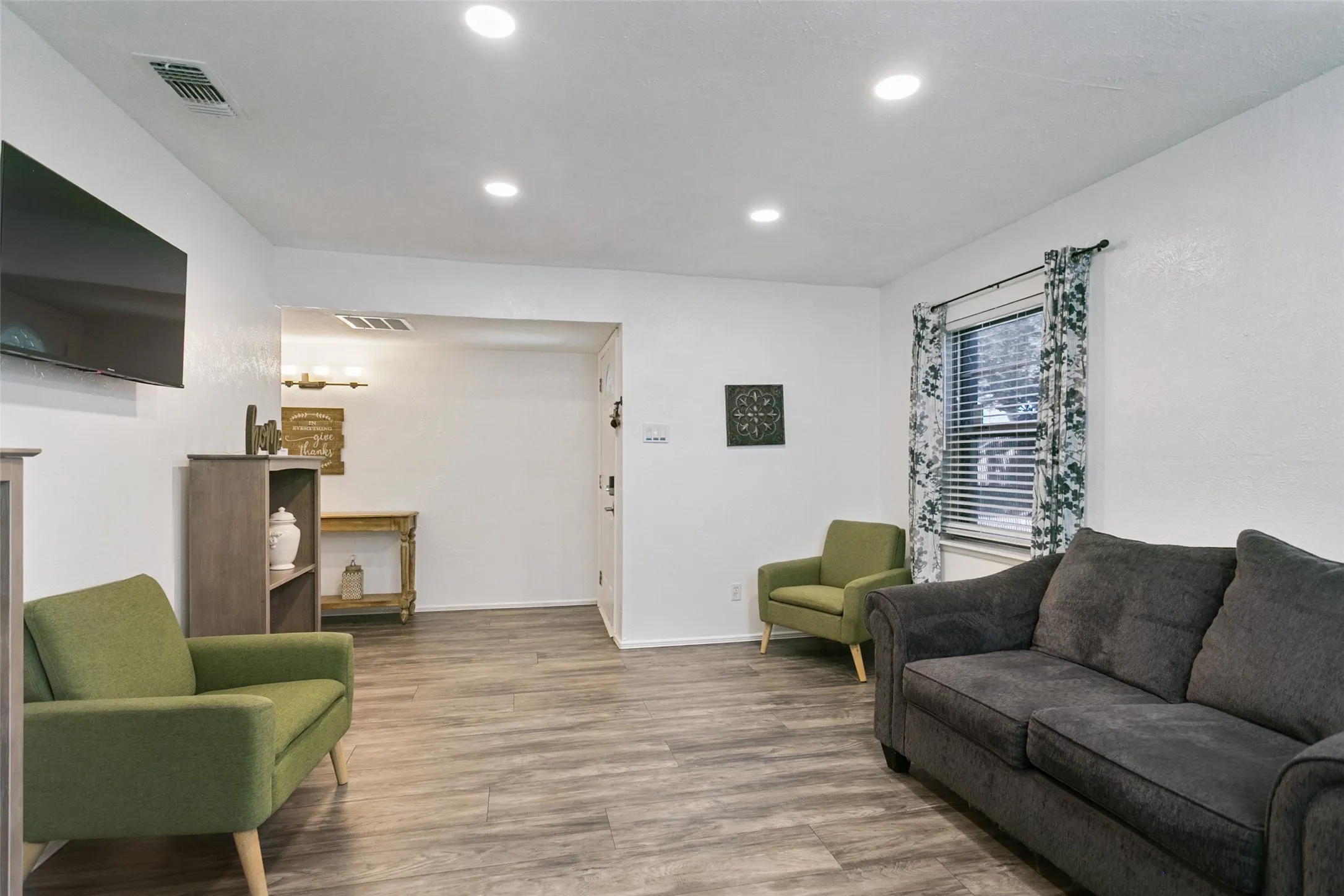 Recessed ceiling lighting, wood-finish flooring, and window with blinds