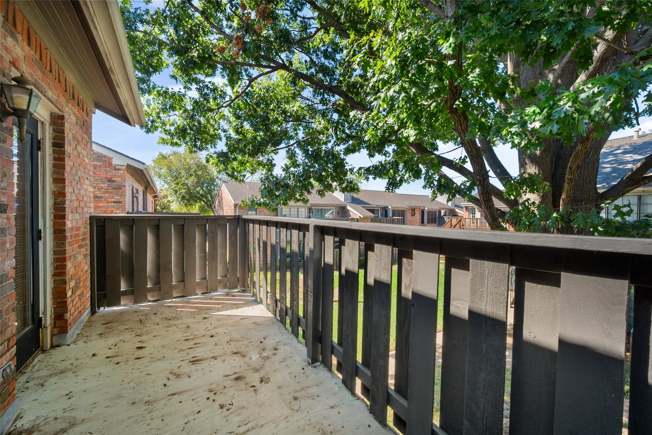 Balcony featuring a concrete surface, dark wood-tone railing that was just redone by Management