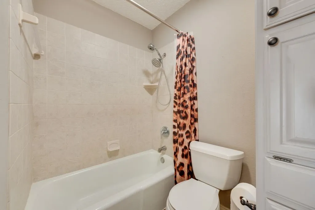 Tub and shower combination with tiled surround, showerhead, and built-in storage