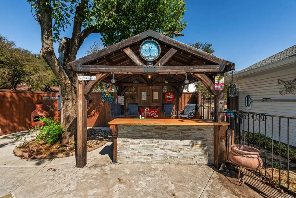 Freestanding wooden gazebo with a built-in bar featuring stone-finish detailing
