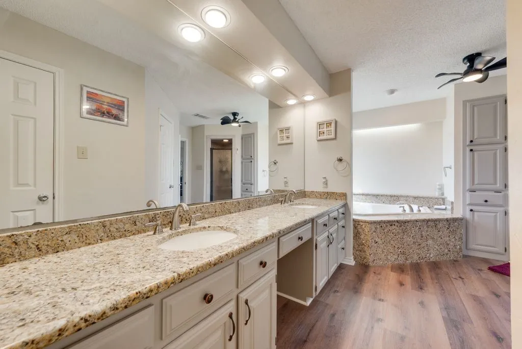 Dual vanity with granite countertops, undermount sinks, and brushed nickel fixtures