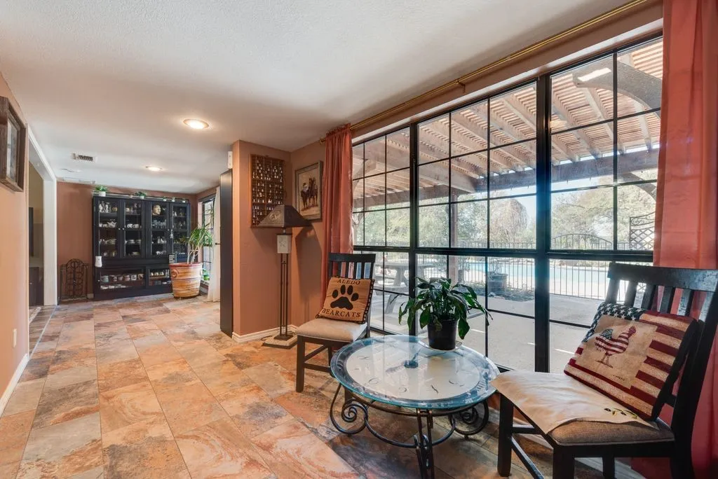Large-format tile flooring, built-in display cabinetry, recessed ceiling lighting, and expansive window framing