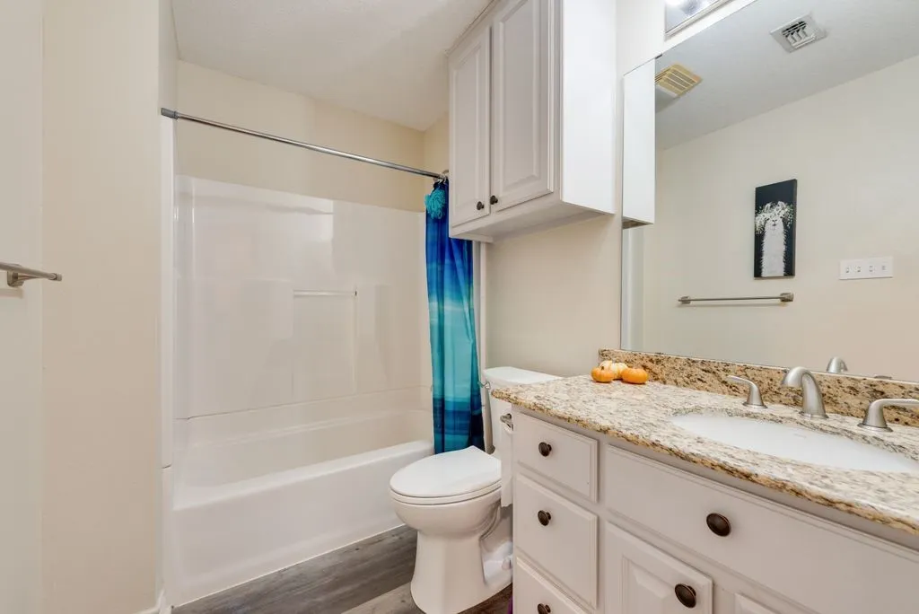 White vanity with dual integrated sinks, granite countertop, and brushed nickel fixtures