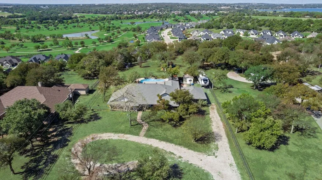 Expansive property featuring a private swimming pool, mature trees, and a detached structure