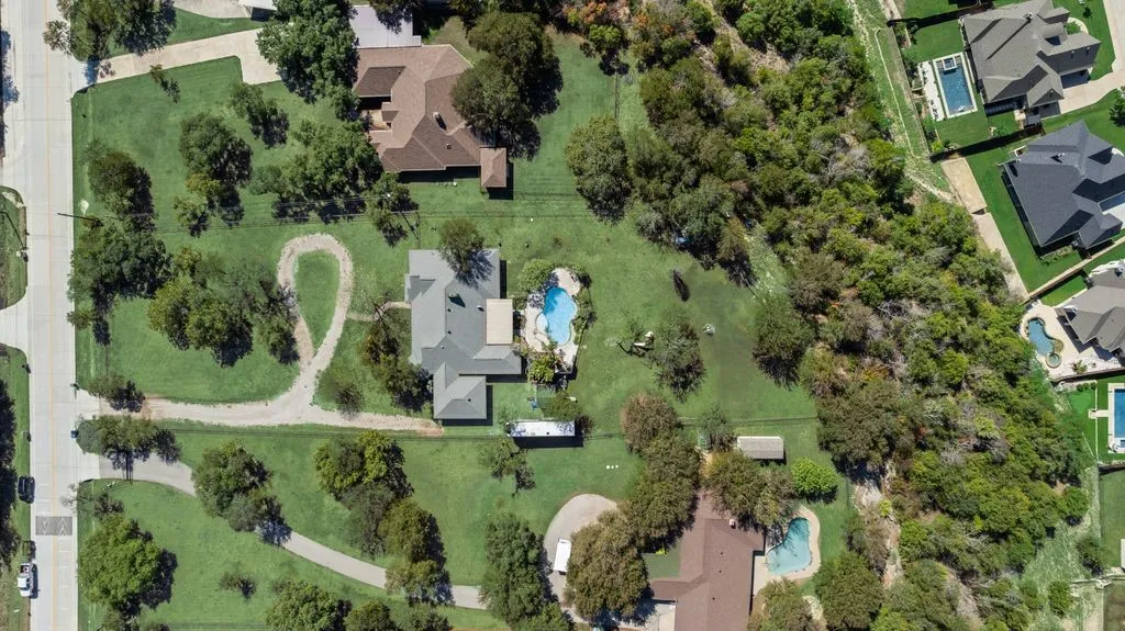 Expansive lot with a central residence, large swimming pool, and extensive green space
