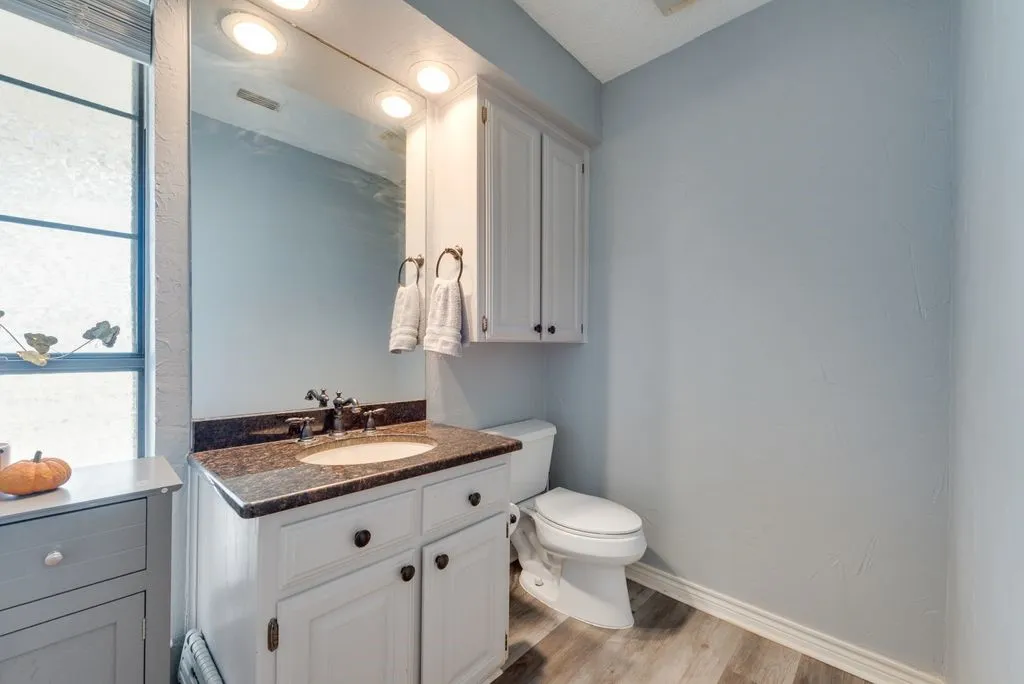 White vanity with a neutral-toned countertop and an undermount sink