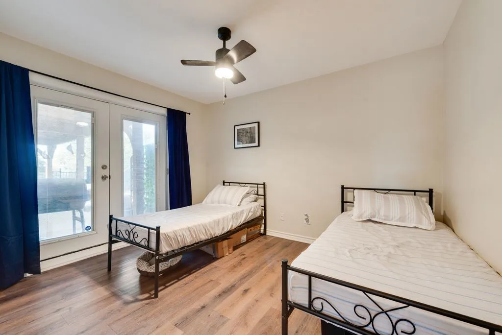Wood-finish flooring, ceiling fan with integrated lighting, and white walls