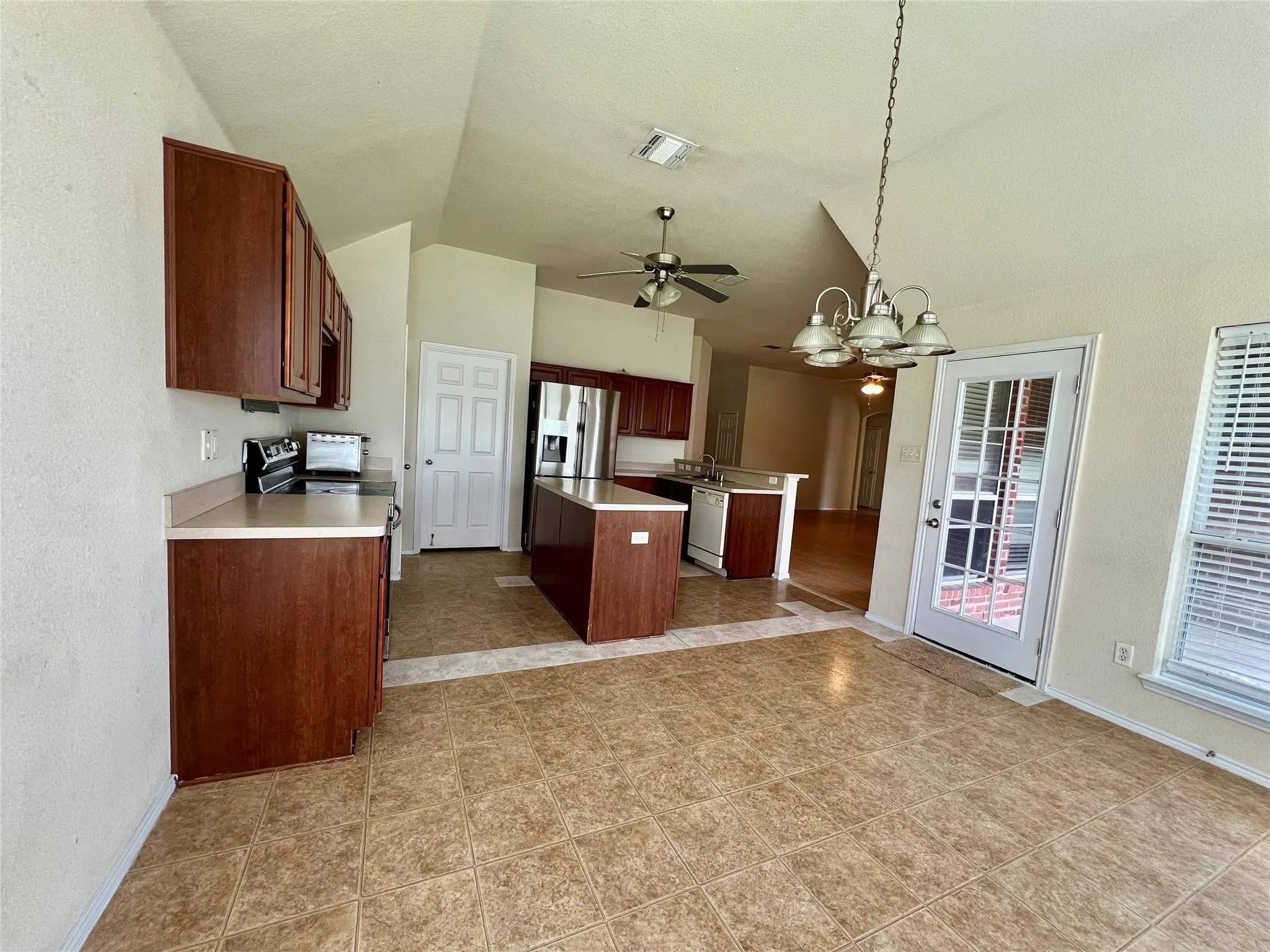 Vaulted ceilings with a ceiling fan, recessed lighting, and a glass-paneled door