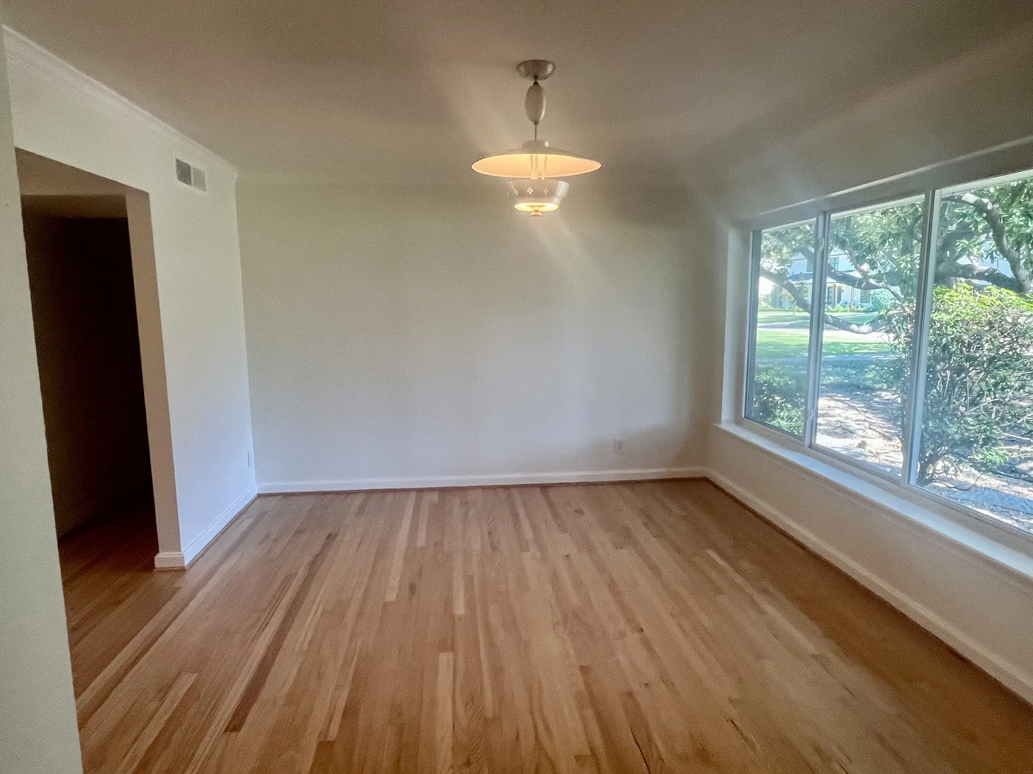 Hardwood flooring, crown molding, white trim, recessed lighting, and a multi-pane window