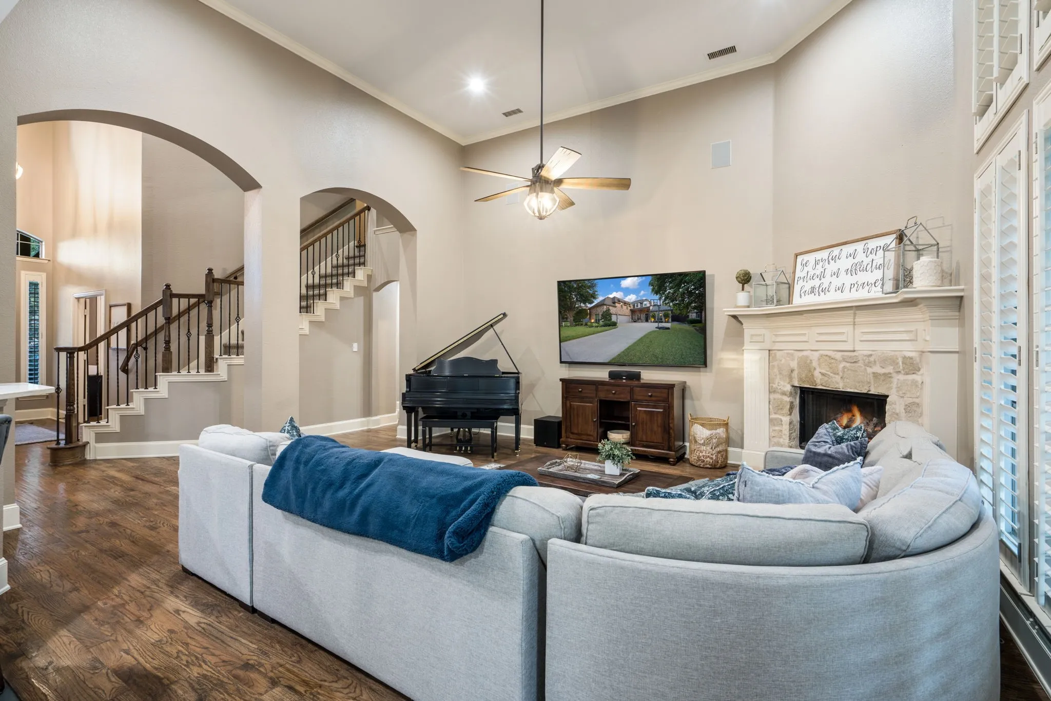 Vaulted ceilings, wood-finish flooring, stone-clad fireplace, and arched doorways