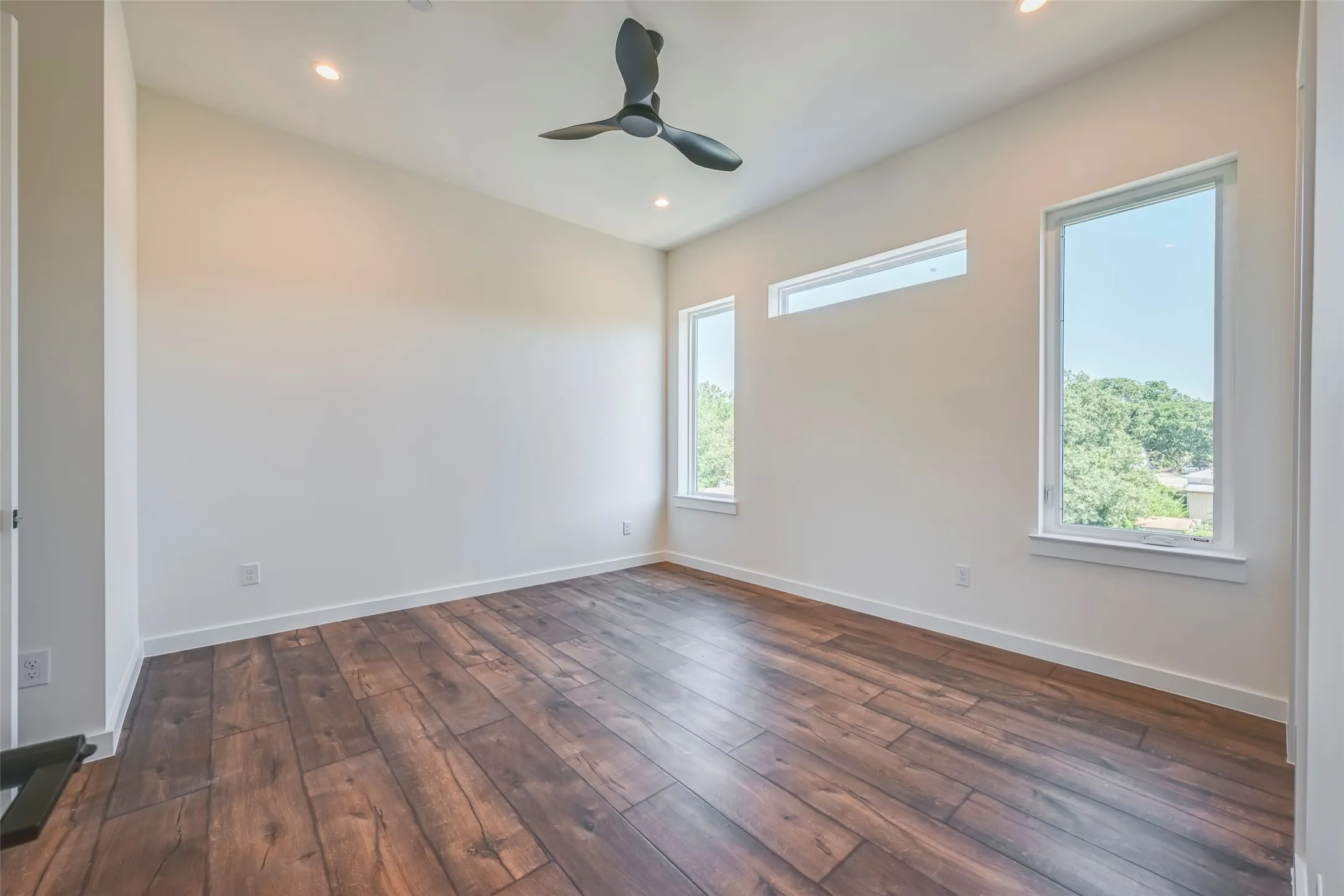 Wood-finish flooring, recessed lighting, contemporary ceiling fan, and multiple windows
