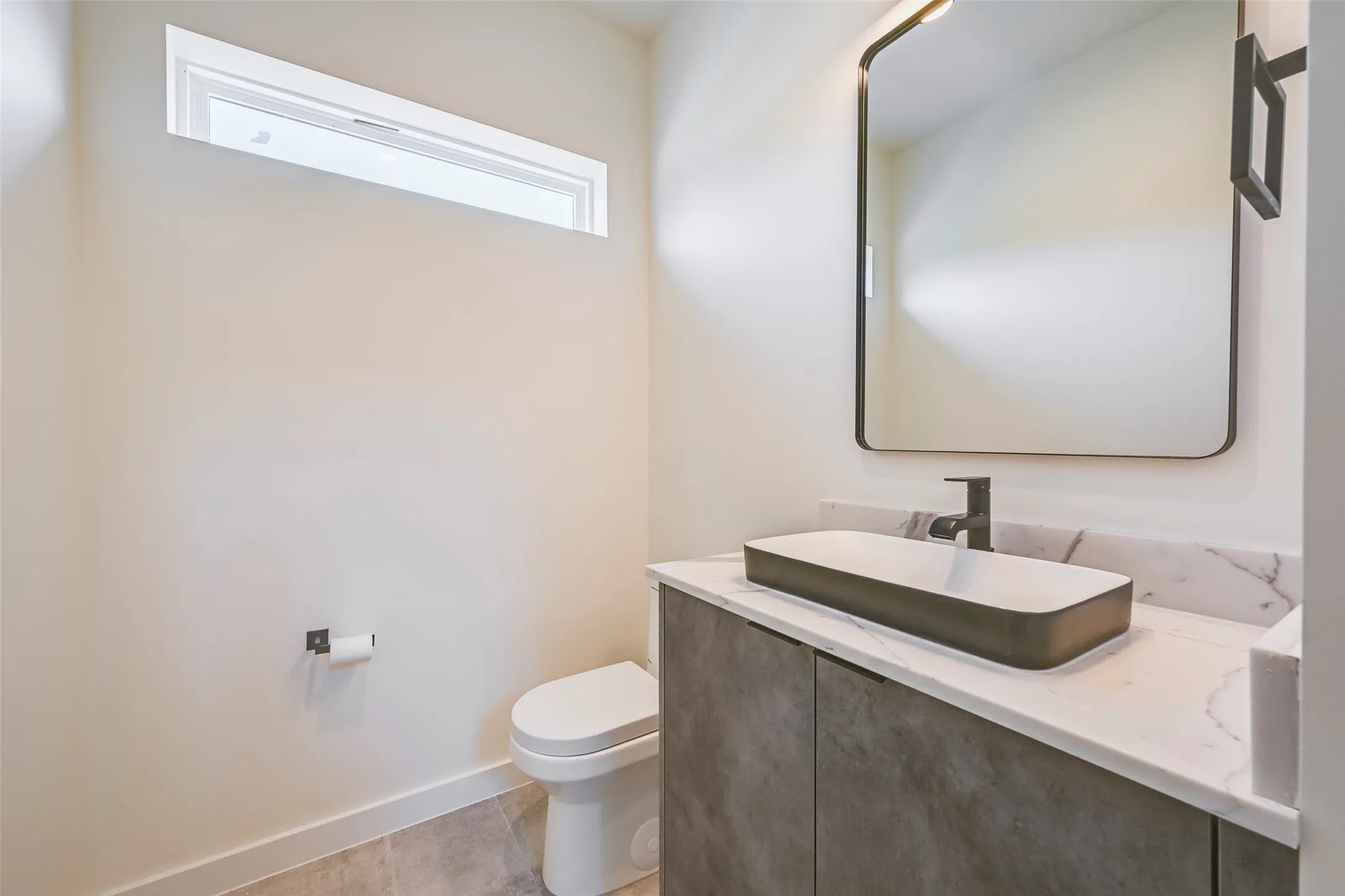 Contemporary vanity with a rectangular vessel sink, matte black faucet, and white countertop