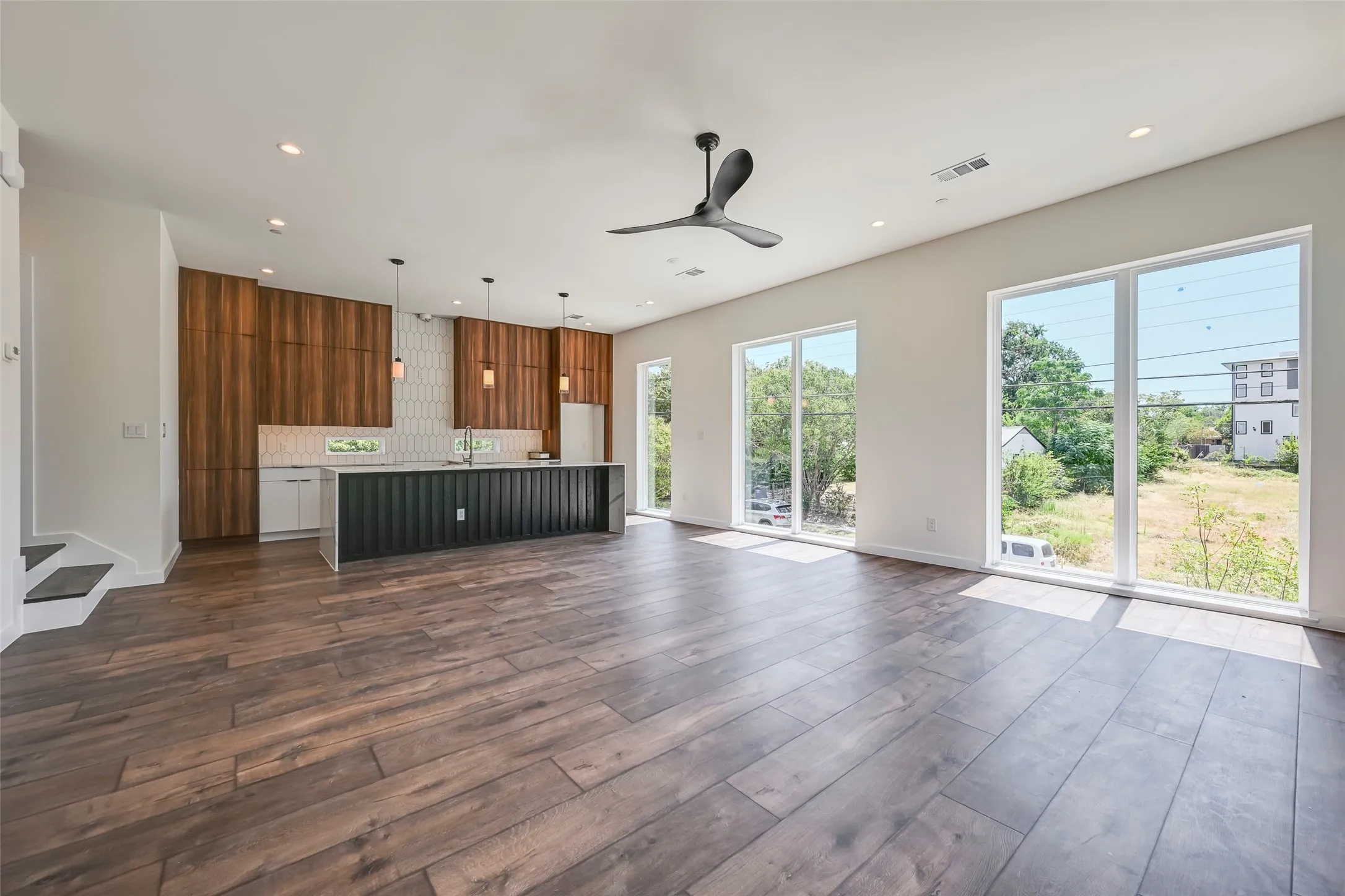 Open-concept living area featuring wood-finish flooring, recessed lighting, and a modern ceiling fan
