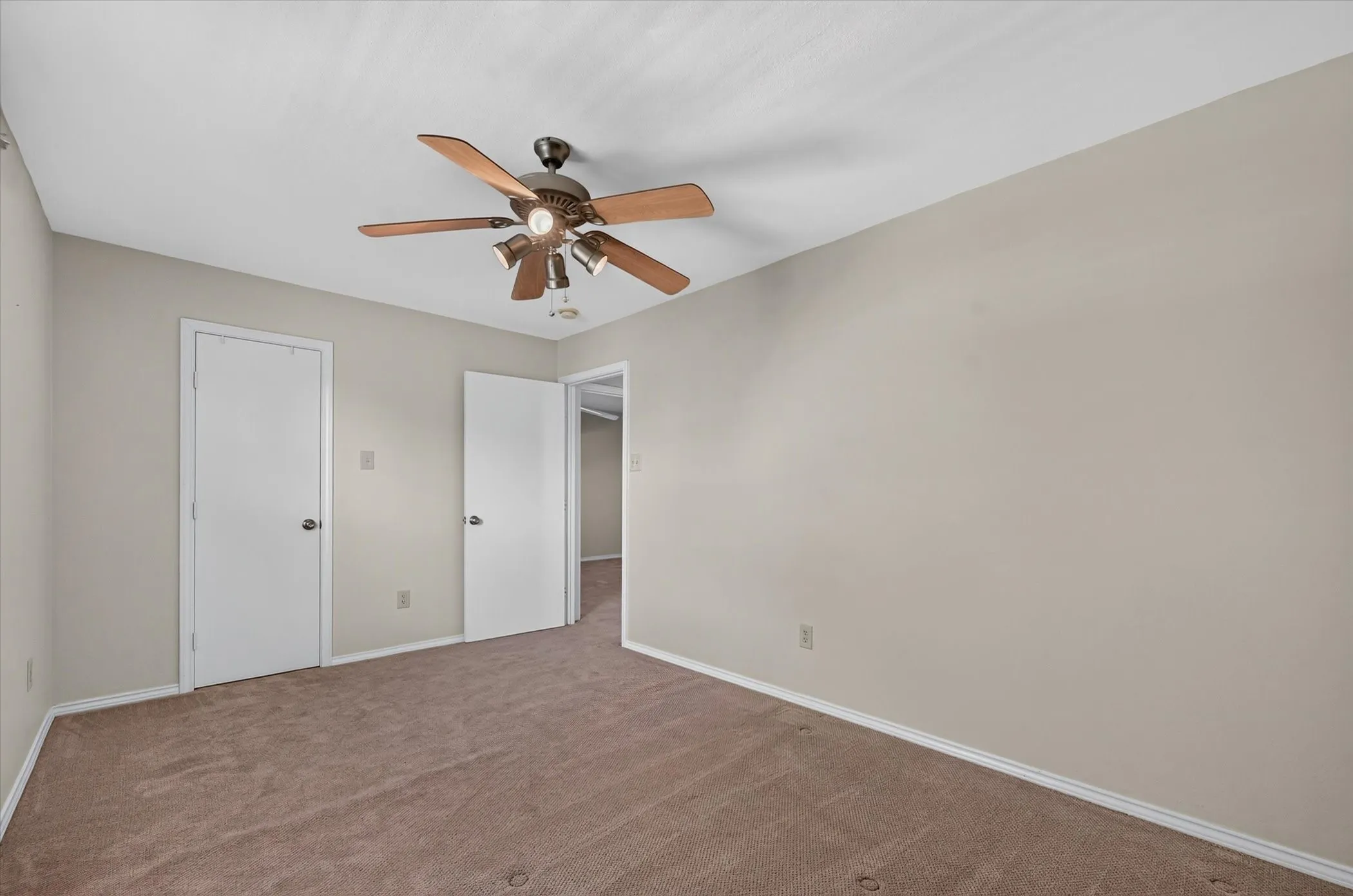 One of two upstairs bedrooms that has a ceiling fan, a walk in closet and upgraded carpet.