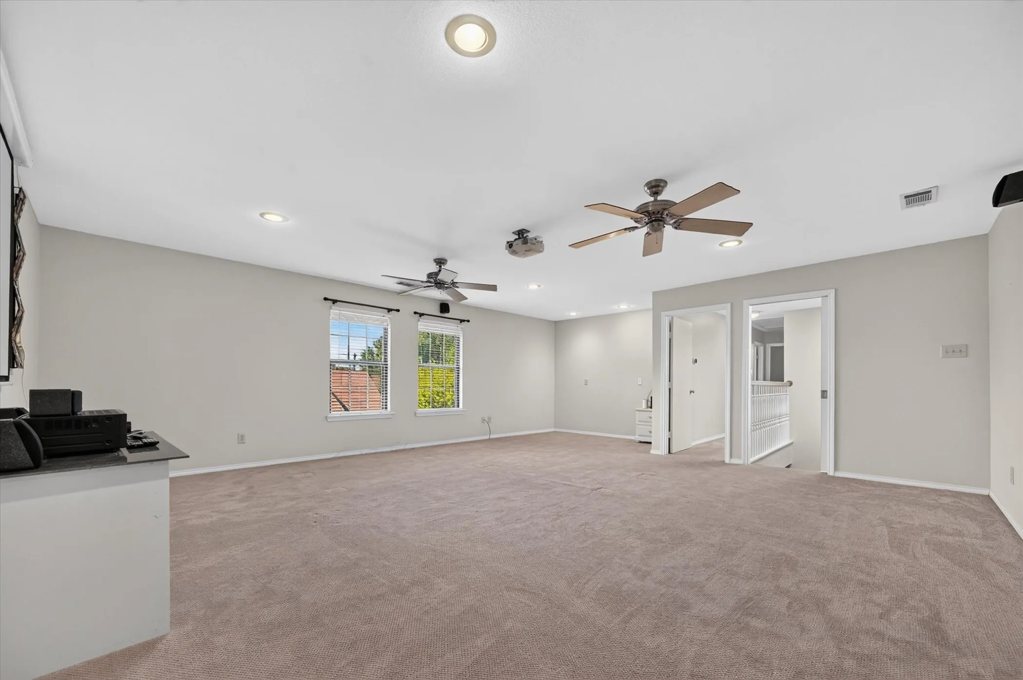 The large upstairs game room has a pocket door at the top of the stairs, 2 fans, projector & screen that will convey with the house. This room is big enough to have set up as a media room and you still have room for game tables.