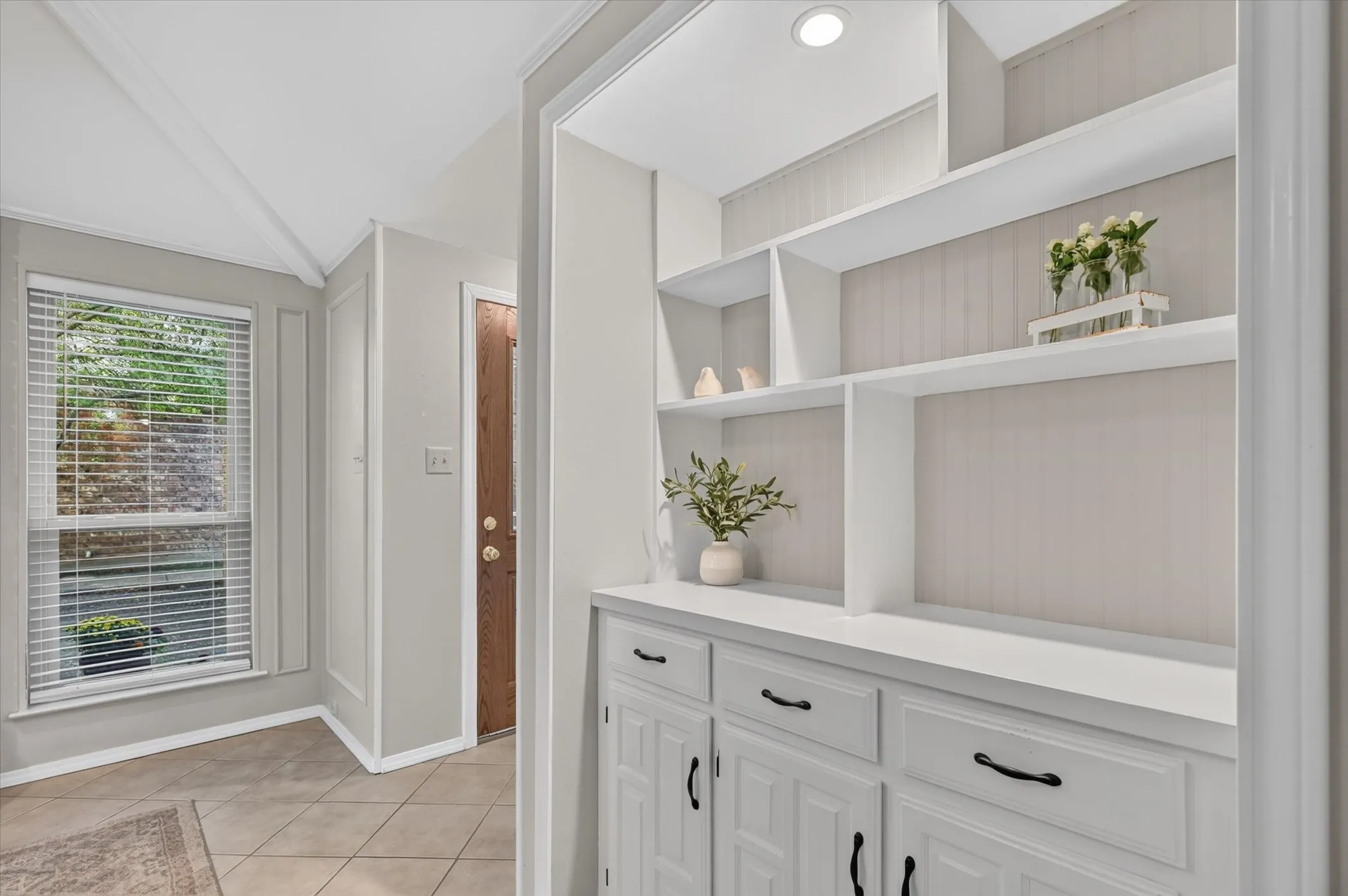 A very pretty built in cabinet with lighting off of the entry.