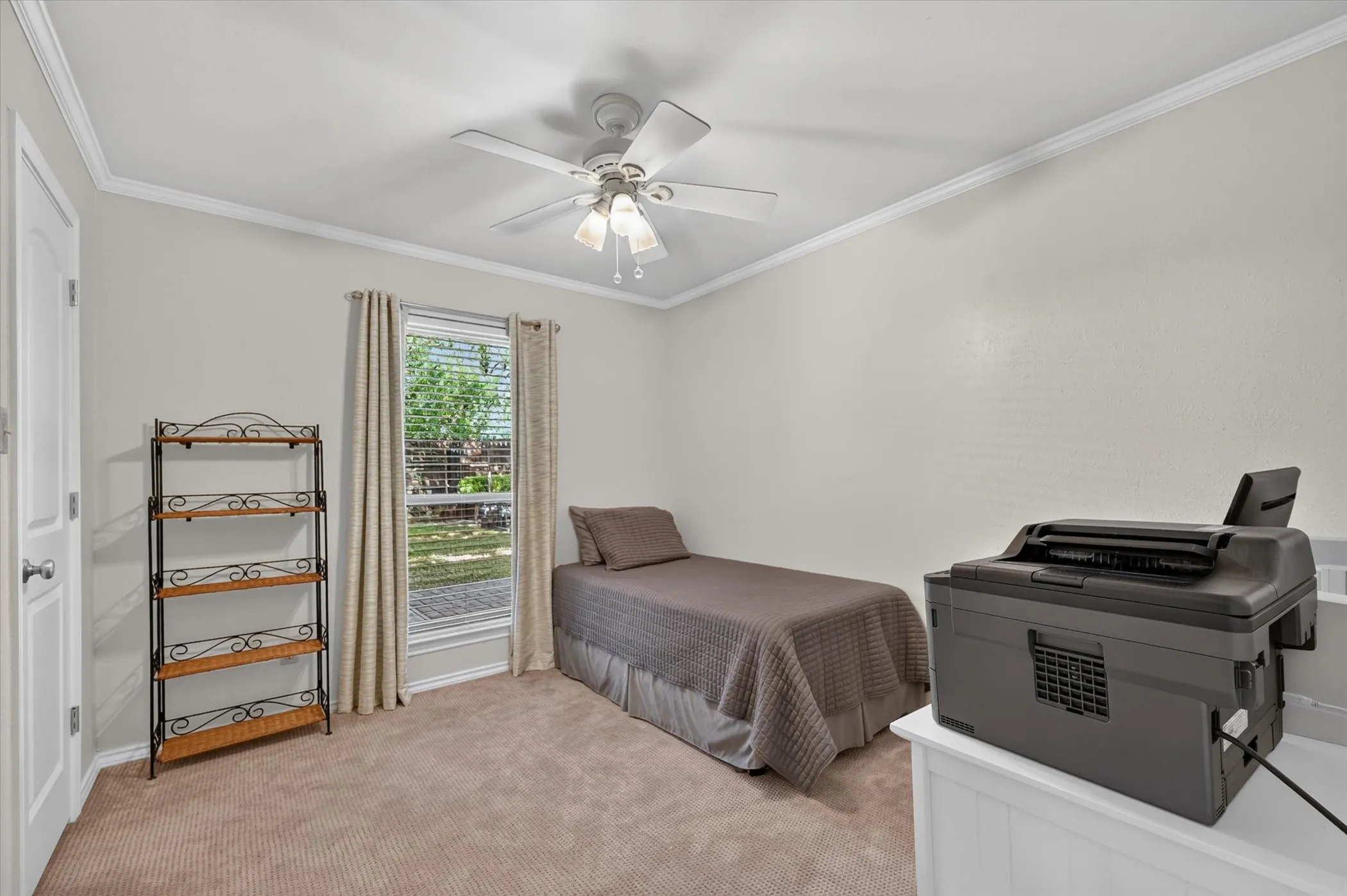 One of two secondary downstairs bedrooms that has a walk in closet & a ceiling fan and upgraded carpet.