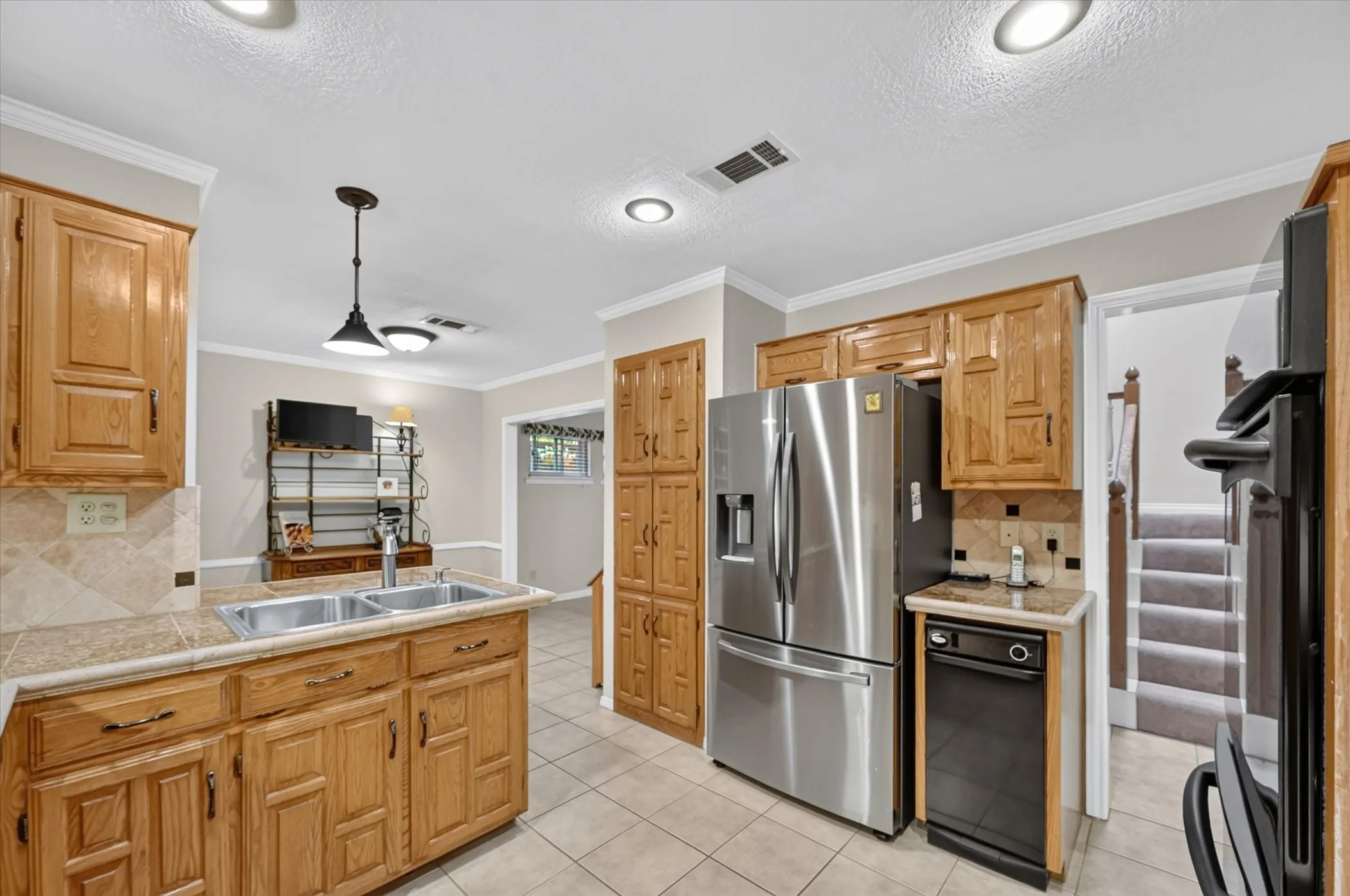The kitchen has a deep double stainless sink, lots of cabinets, trash compactor & looks into the breakfast area.