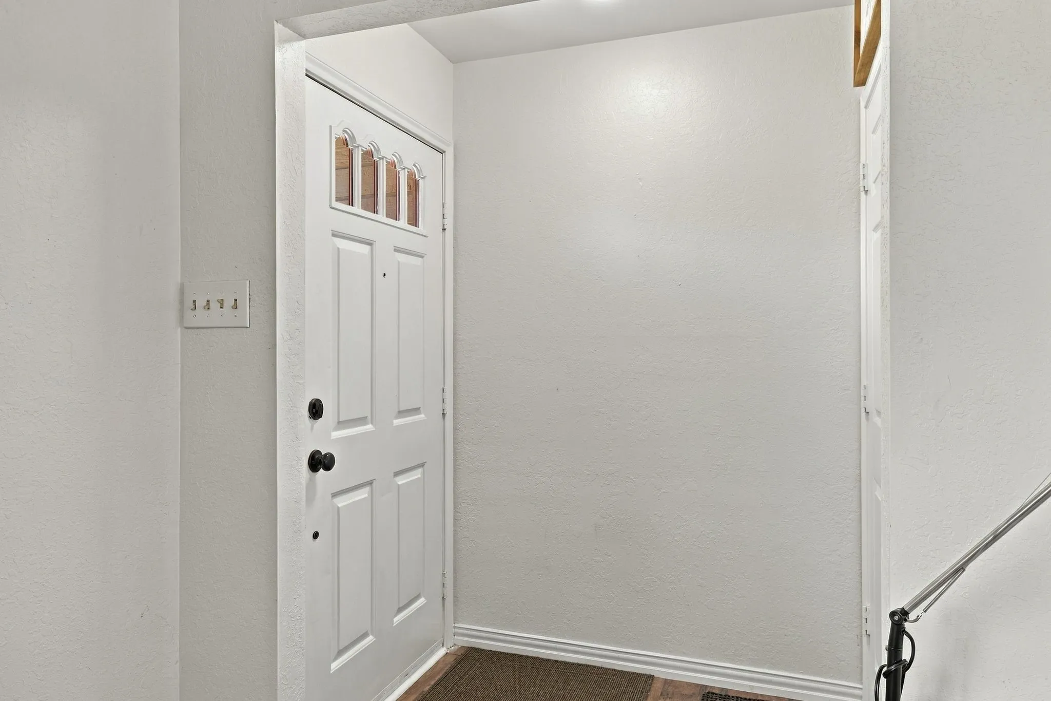 White paneled door with decorative glass inserts and black hardware