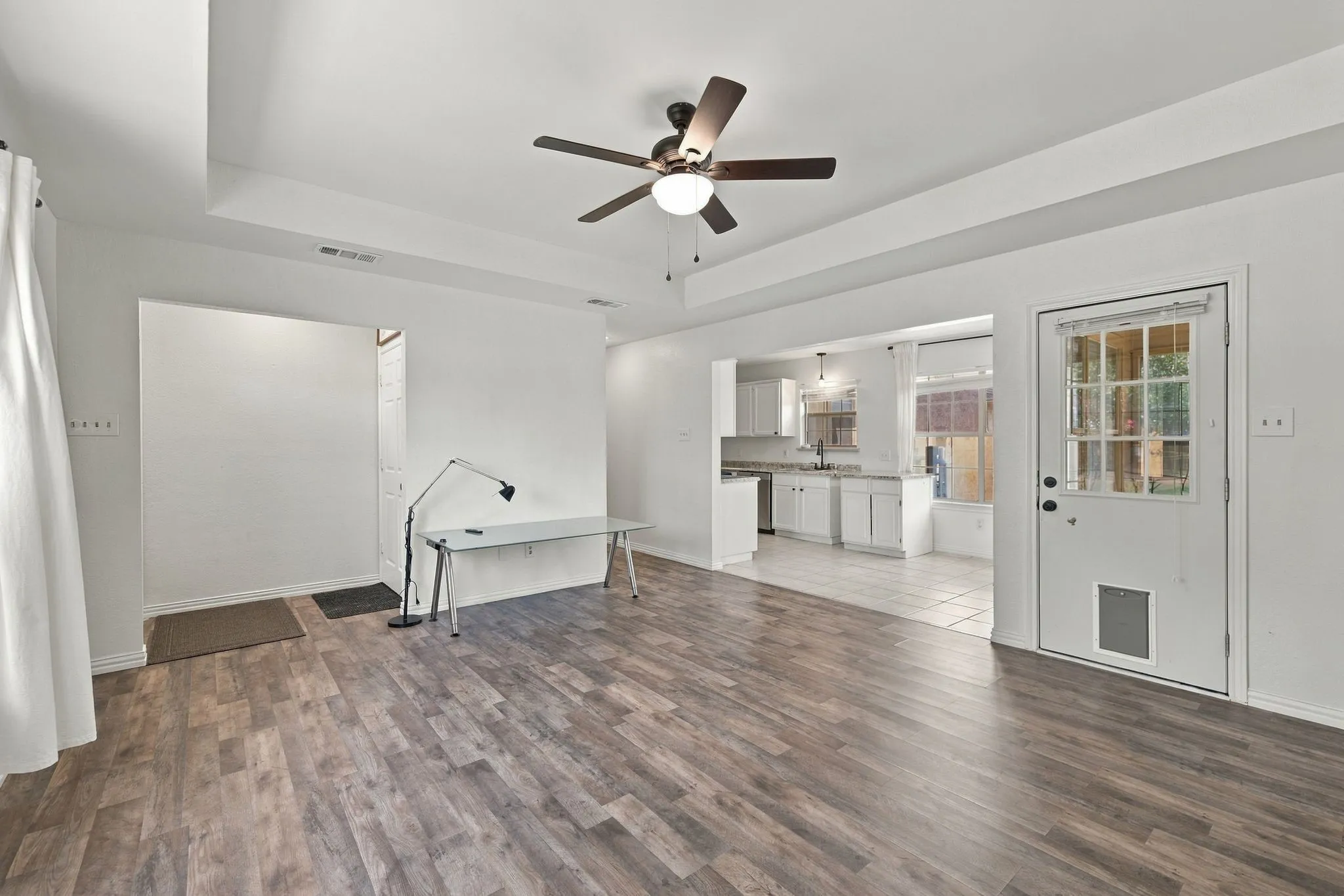 Wood-finish flooring throughout, tray ceiling, and ceiling fan