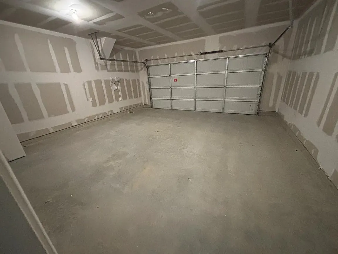 Attached garage featuring a concrete floor and a panel garage door