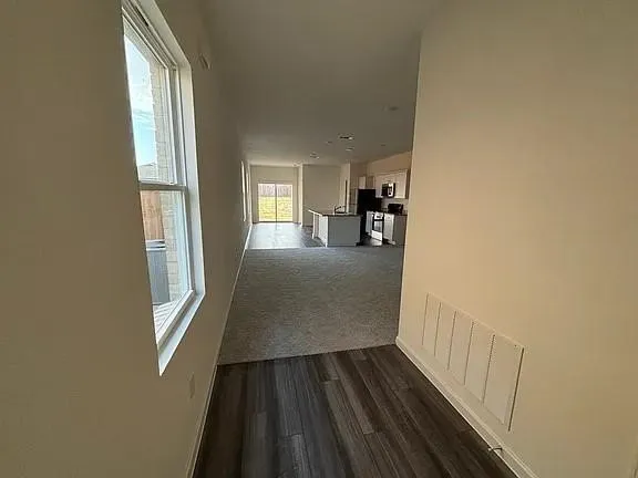 Wood-finish flooring, light-toned walls, and a large window