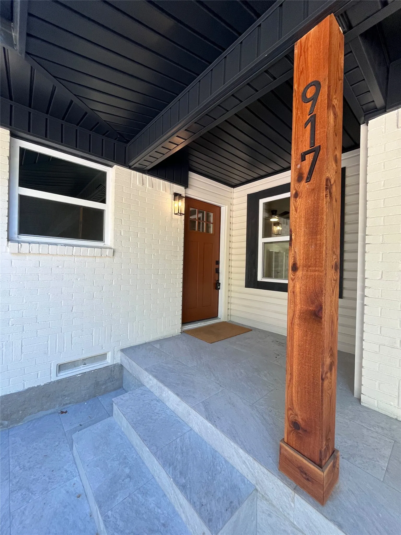 Brick and siding exterior with a wood-finish entry door