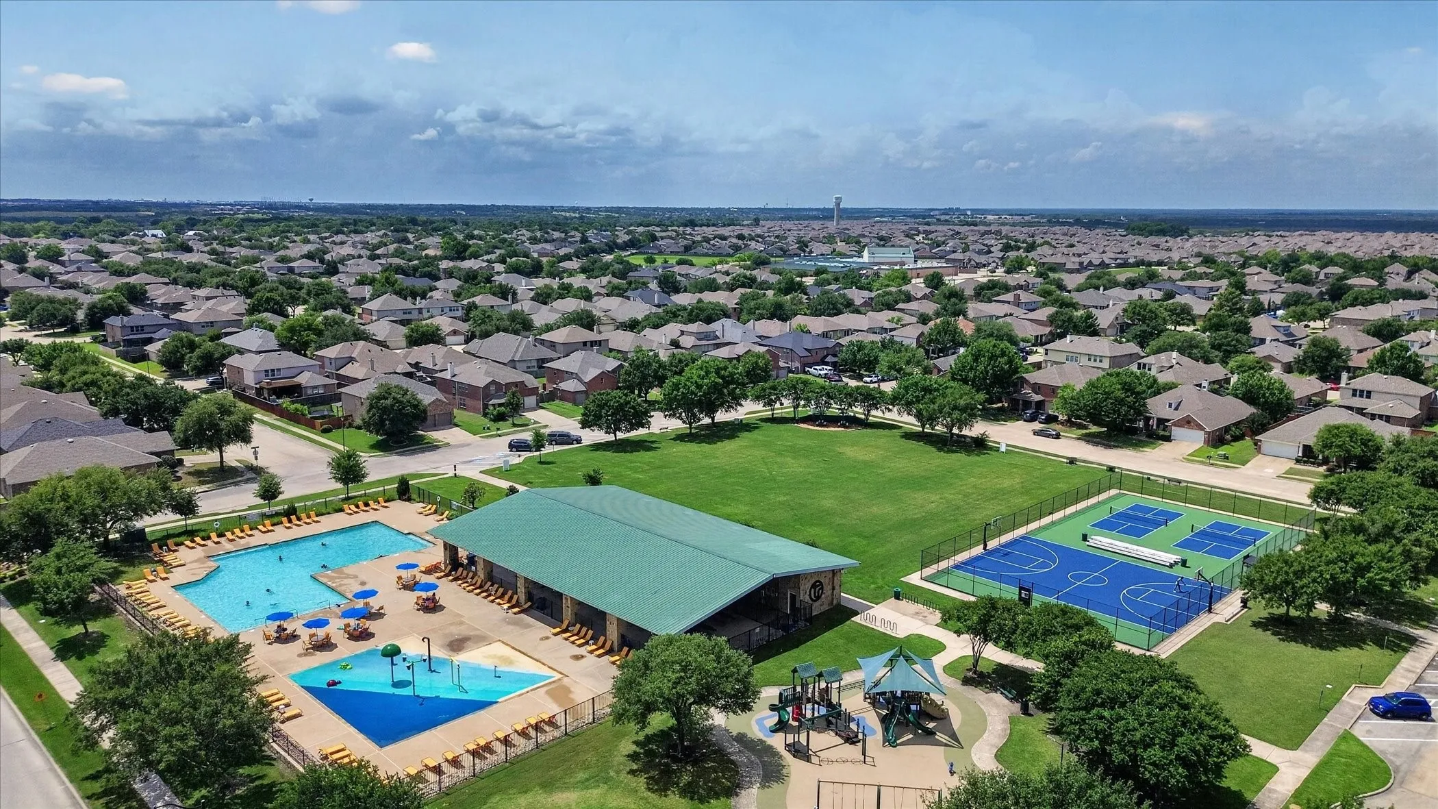 Community pool, separate splash pad, multi-sport courts, open green space, and playground structure
