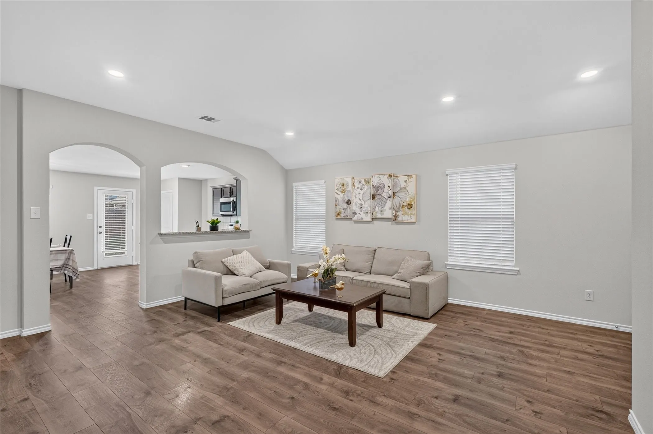 Wood-finish flooring throughout, recessed lighting, and arched doorways