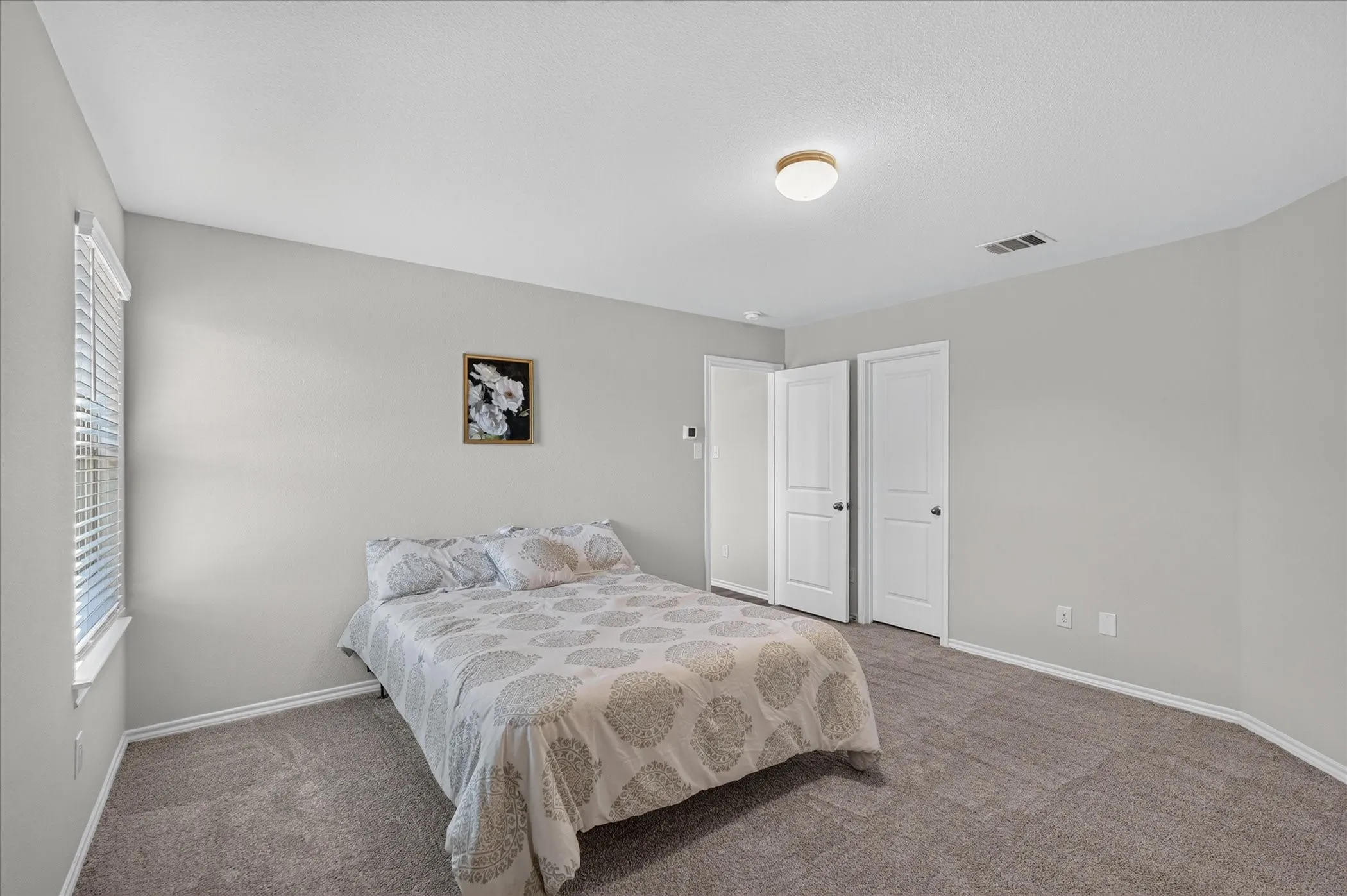 Neutral-toned walls complement plush carpeting