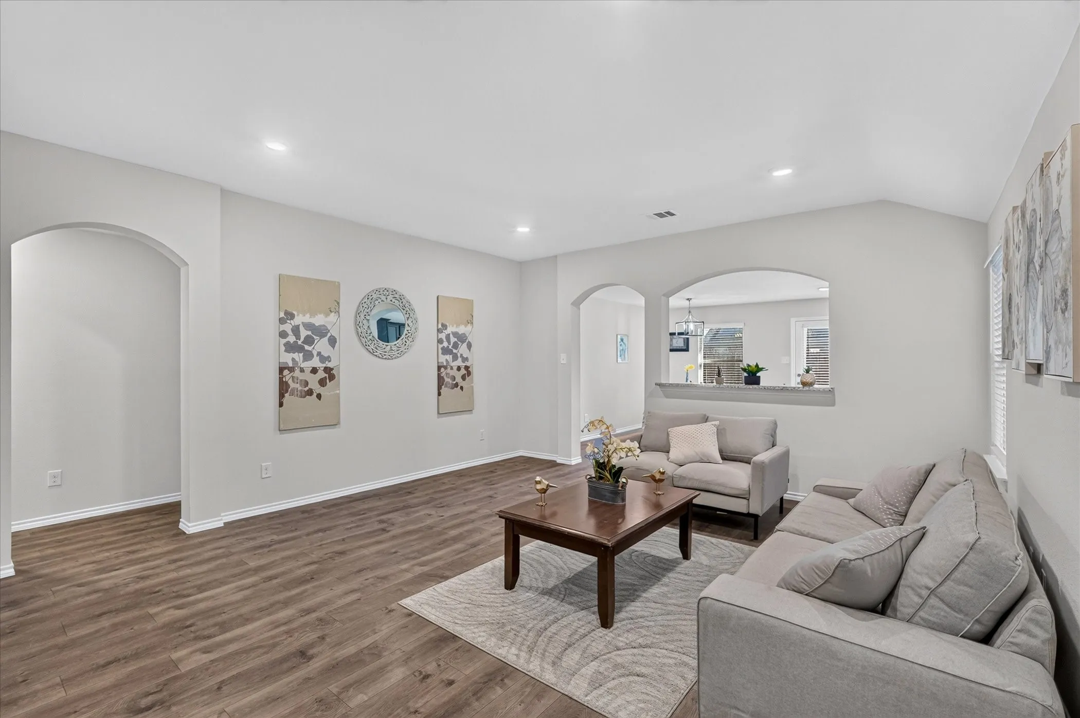Vaulted ceilings, recessed lighting, wood-finish flooring, arched doorways, and an interior pass-through window