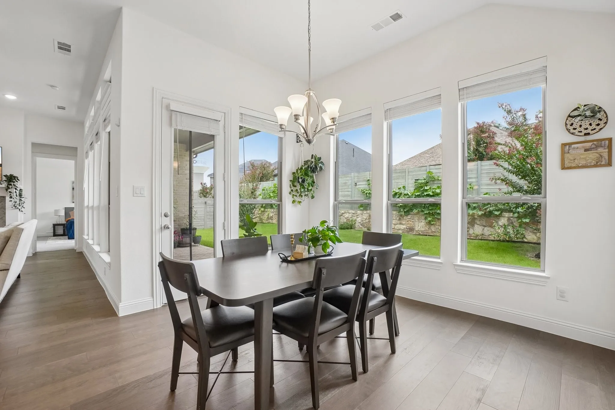 Vaulted ceiling, wood-finish flooring, multiple large windows, glass-paneled exterior door, recessed lighting