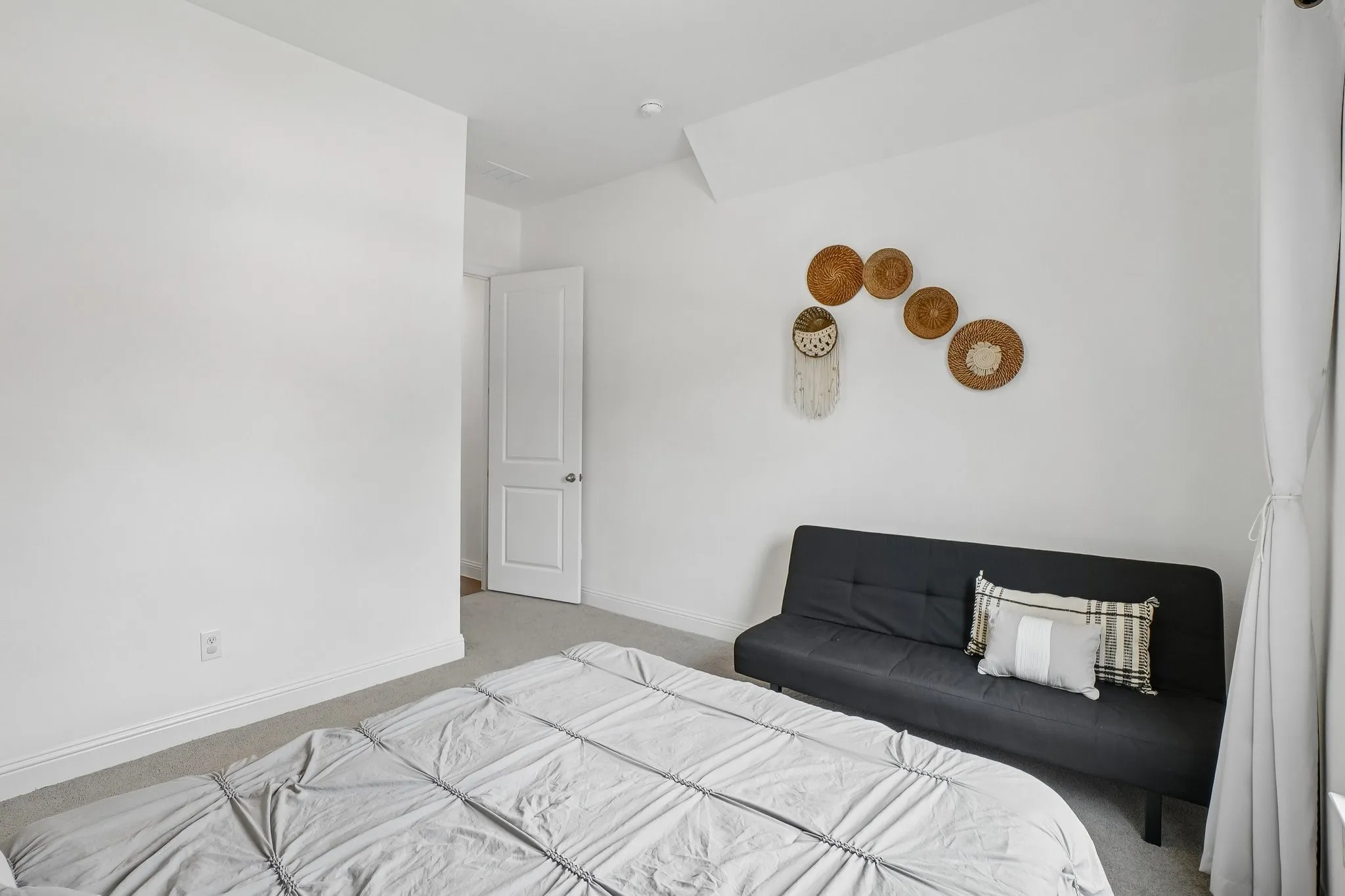 White walls, light-colored carpeting, and a white interior door