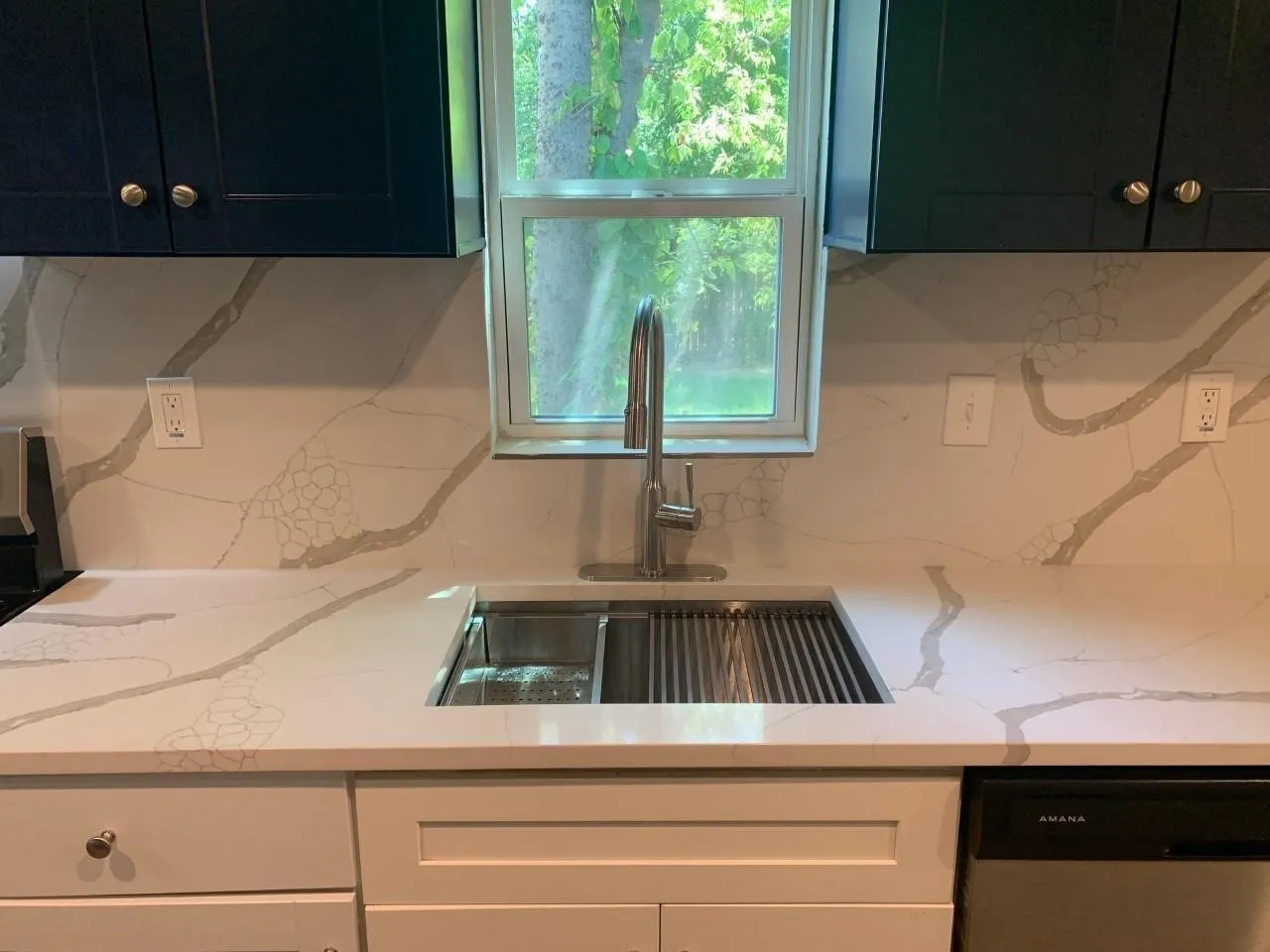 Quartz countertops with integrated sink and matching full-height backsplash