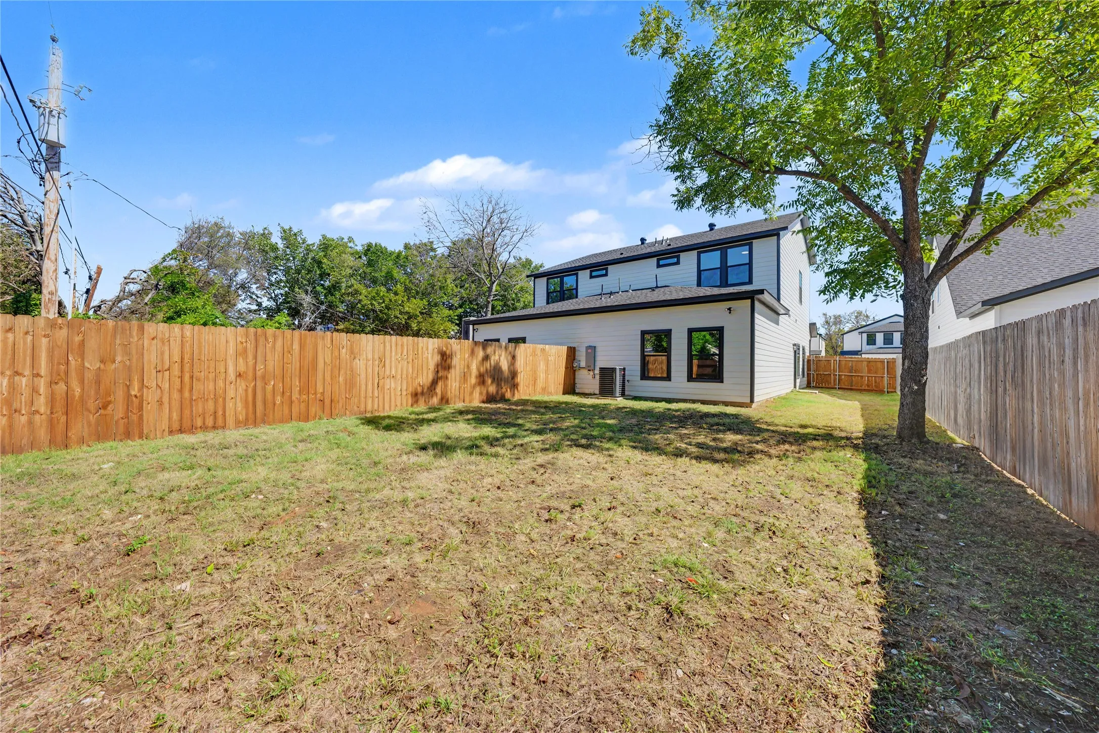 Expansive backyard featuring a new wood privacy fence.