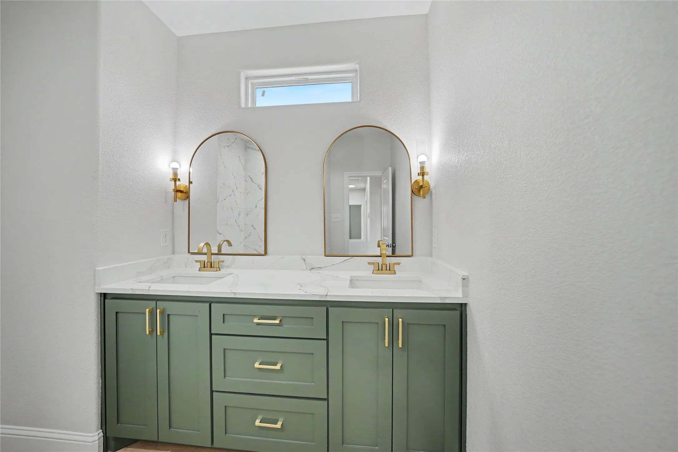Dual vanity with a white countertop, undermount sinks, and gold-finish faucets