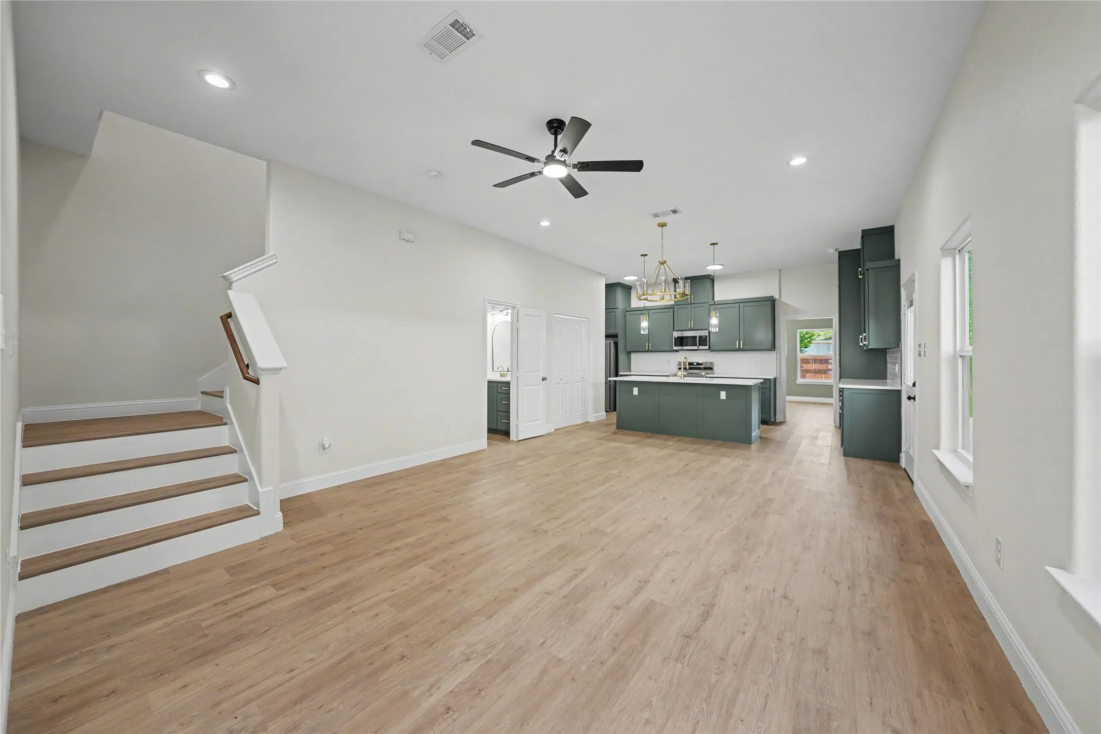 Open-concept living area featuring wood-finish flooring, recessed lighting, and a modern ceiling fan