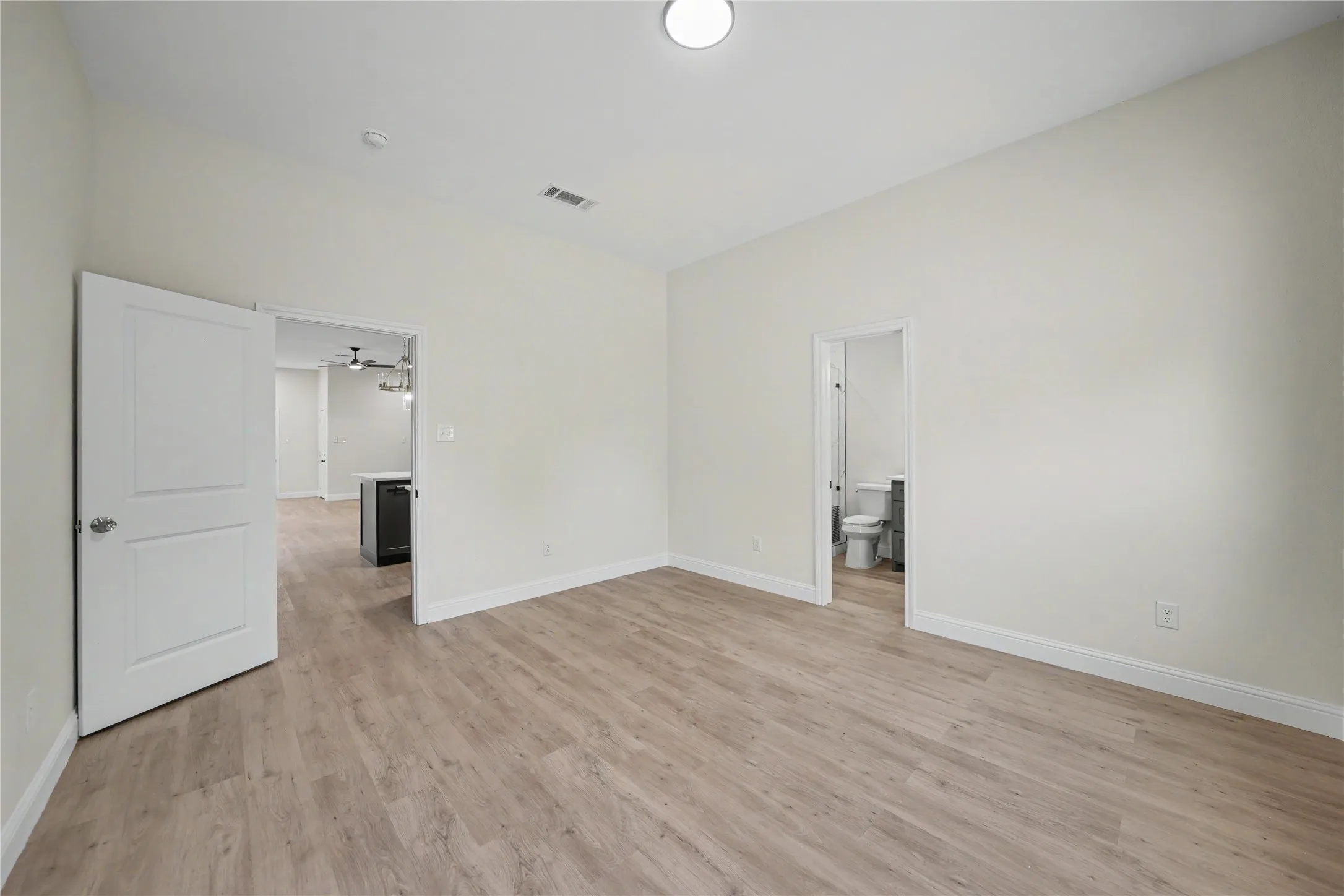 Spacious room with wood-finish flooring and neutral wall tones