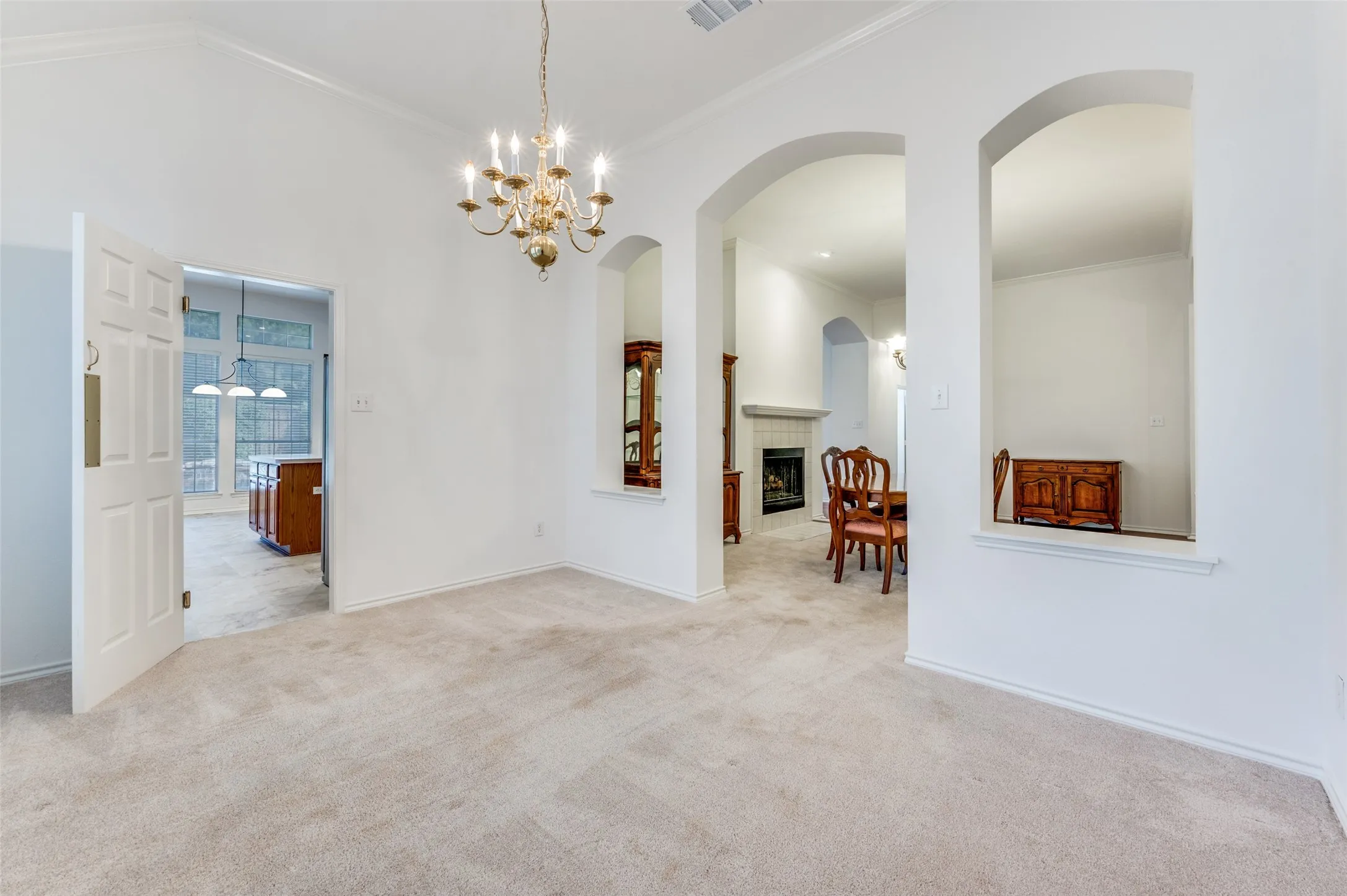 Dining Room with a chandelier adjacent to a formal living room or sitting room with a double-sided fireplace.