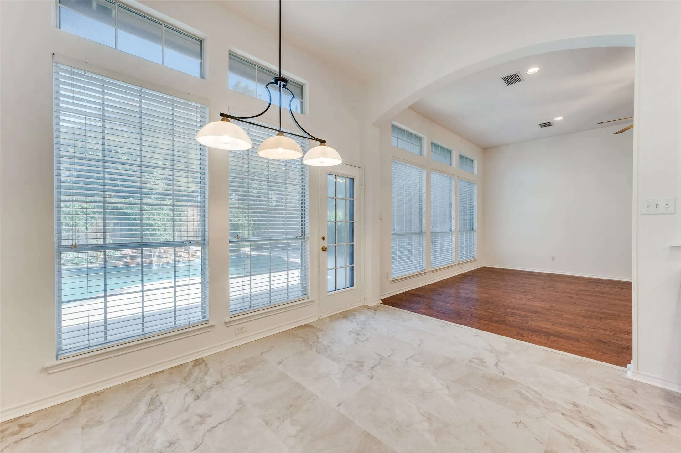 Breakfast area with easy-to-maintain tile floors and a view of the open walkway into the den area with a fireplace.