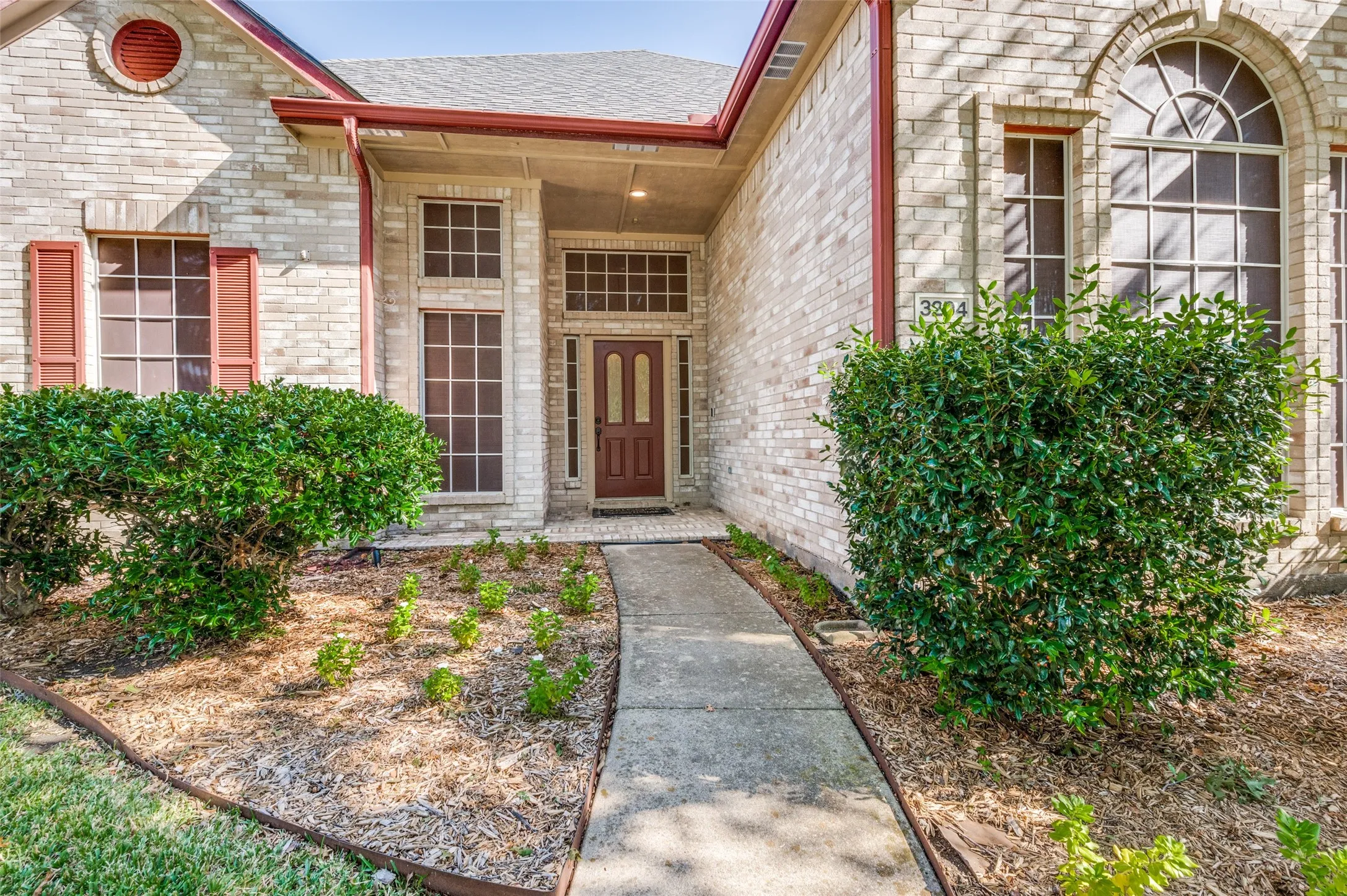 Brick exterior with red-toned gutters and trim