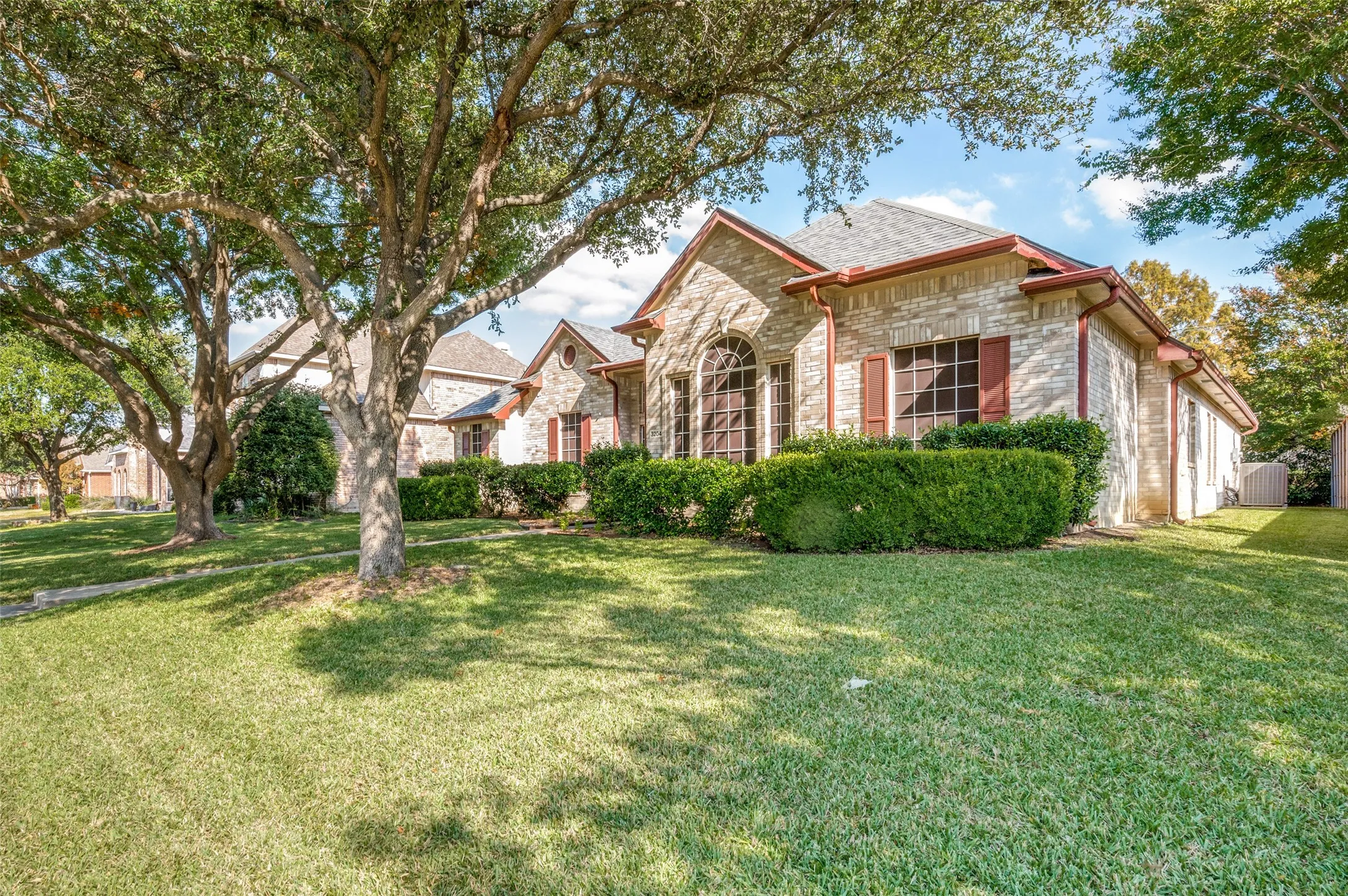 Nicely landscaped front elevation of this beautiful home. Two majestic oak trees shade the home's front.