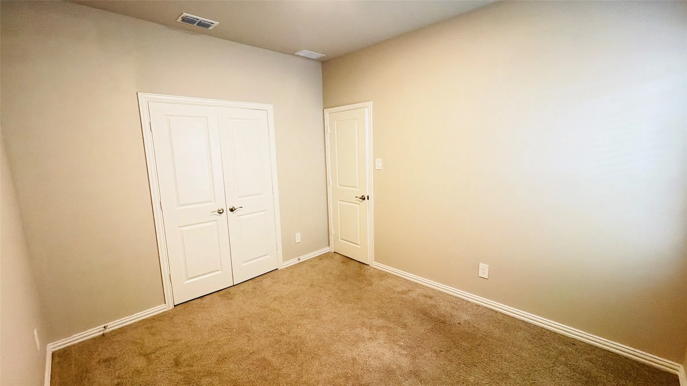 Neutral-toned walls complement plush carpeting