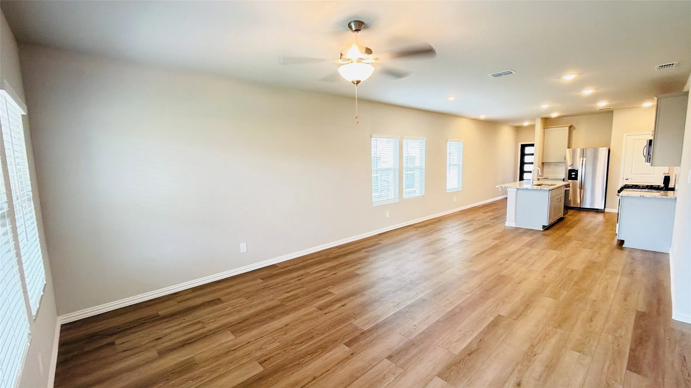 Open concept living area featuring wood-finish flooring, recessed lighting, and a ceiling fan