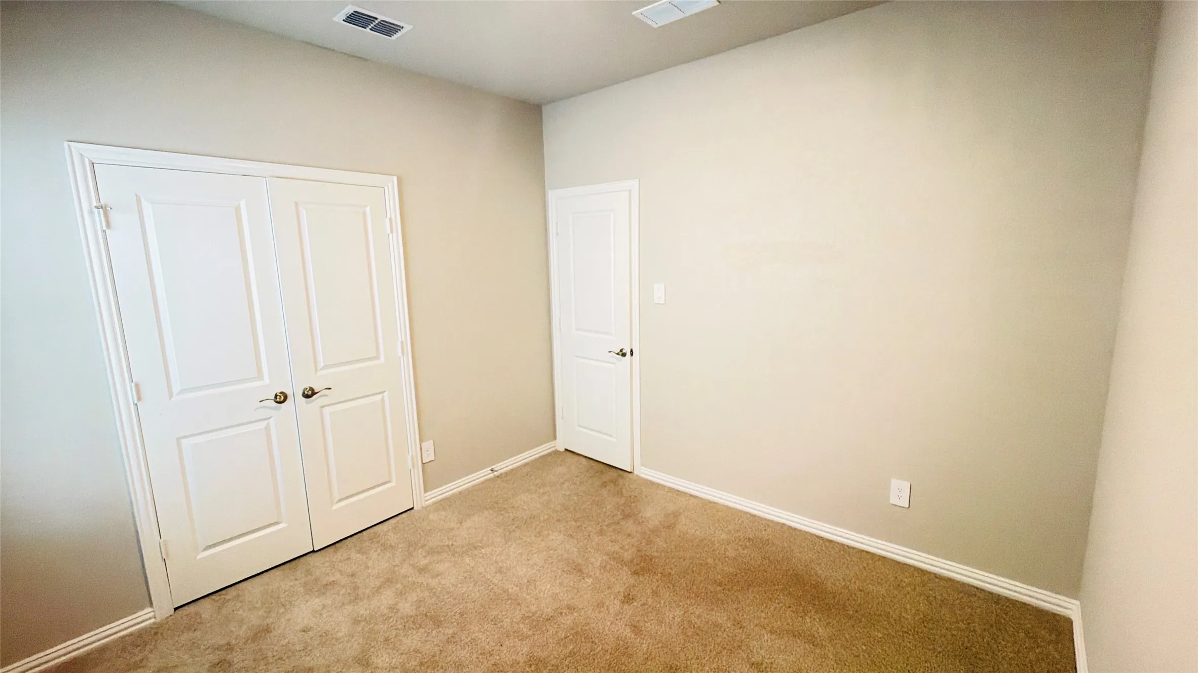 Wall-to-wall carpeting, light-toned wall paint, and white trim