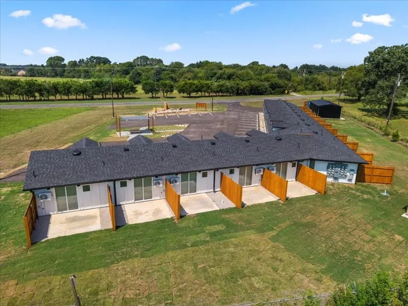 Single-story multi-unit structure with individual rear patios, and private wooden fence dividers